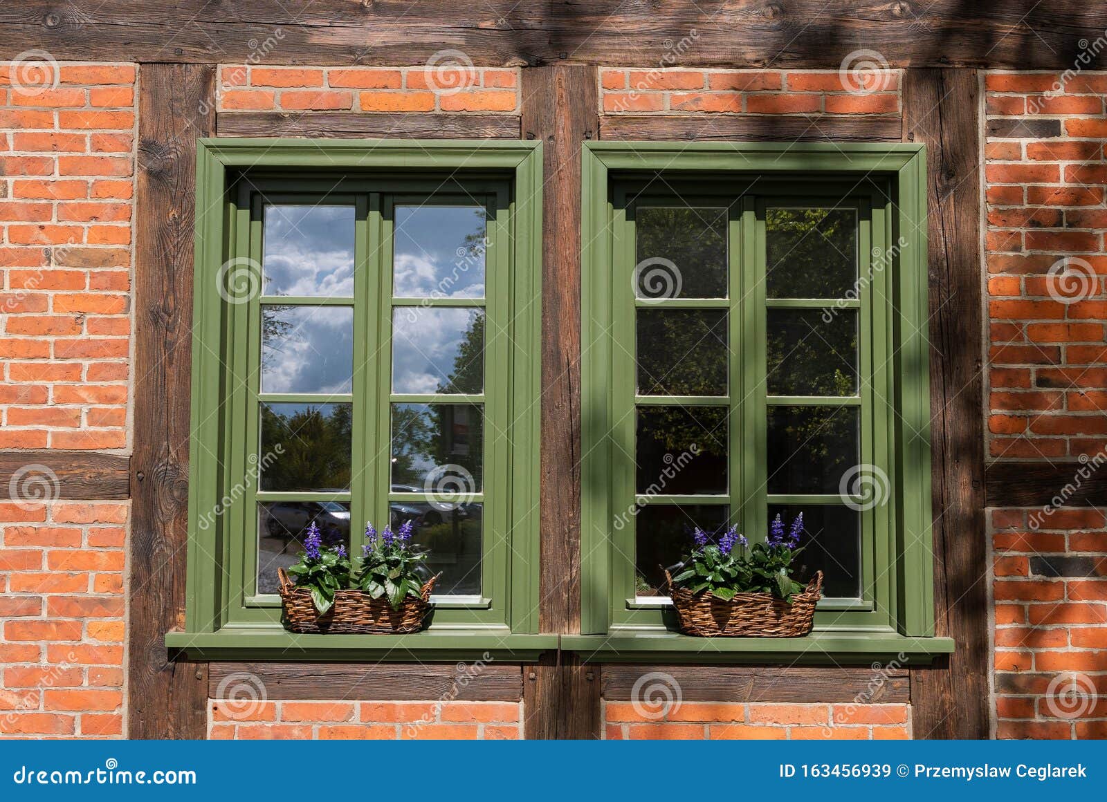 Windows with Green Frames and Decorated by Flowers in Baskets Stock