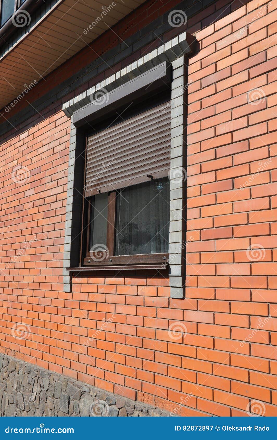 Windows with Rolling Shutter on the New Brick House Construction Facade
