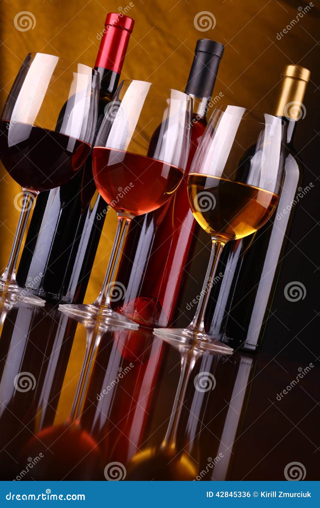 Wine för flaskexponeringsglas. Exponeringsglas och flaskor av rött, rosa och vitt vin över en draperad bakgrund tände guling