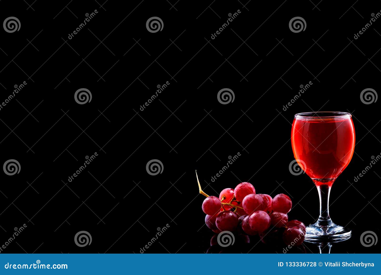 wine glass and red grapes with drops on blak backgound. space fot text menu