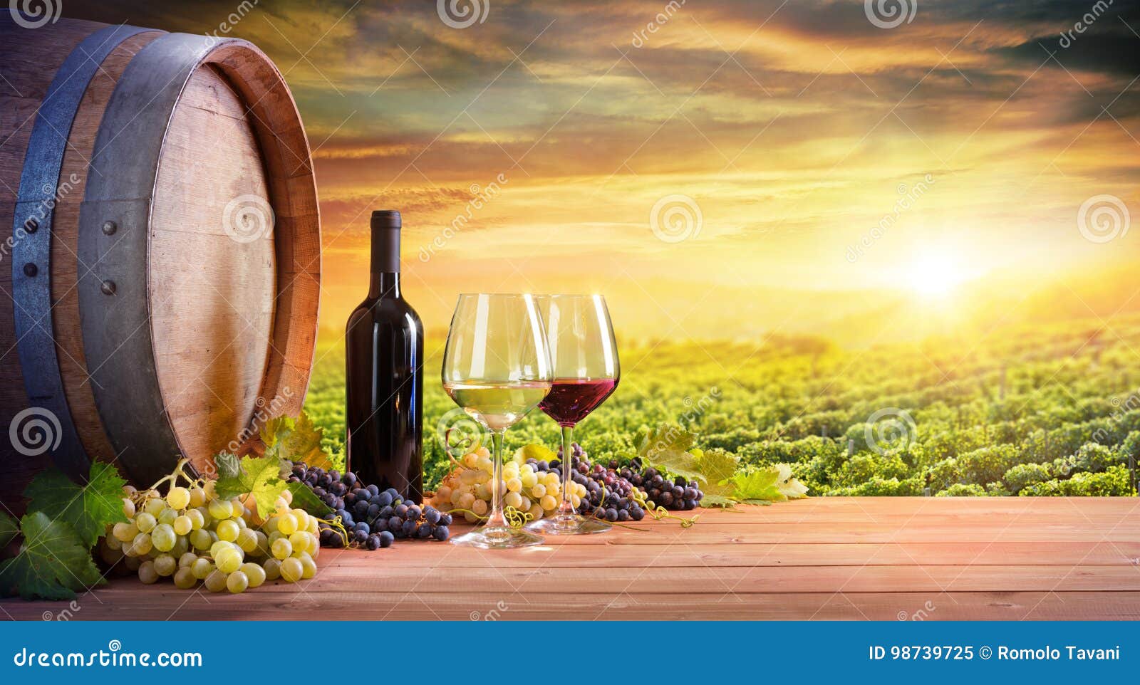 wine glasses and bottle with barrel in vineyard