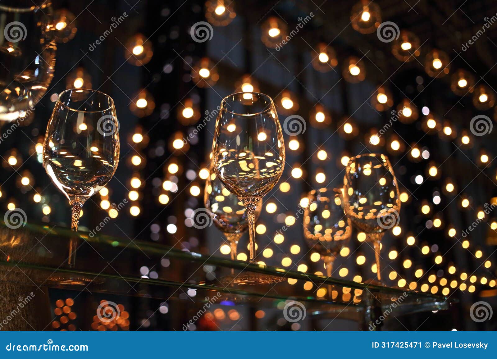 wine glasses on a glass table illuminated lots of