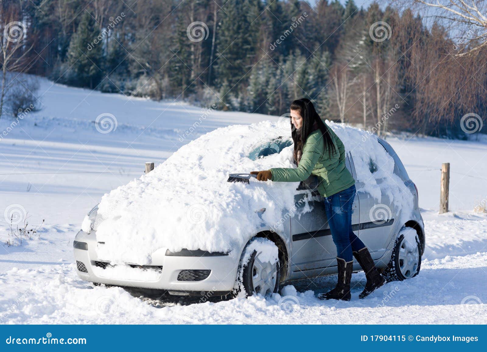 winter car - woman remove snow from windshield