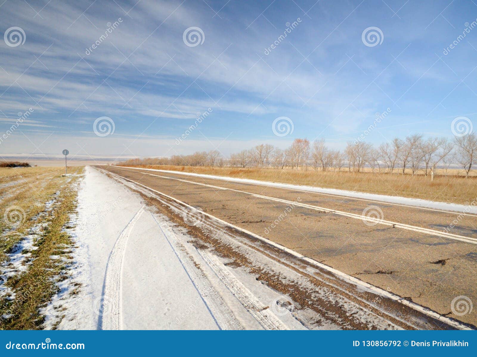 Winter Landscape with Asphalt Road, Bare Trees and First Snow Under