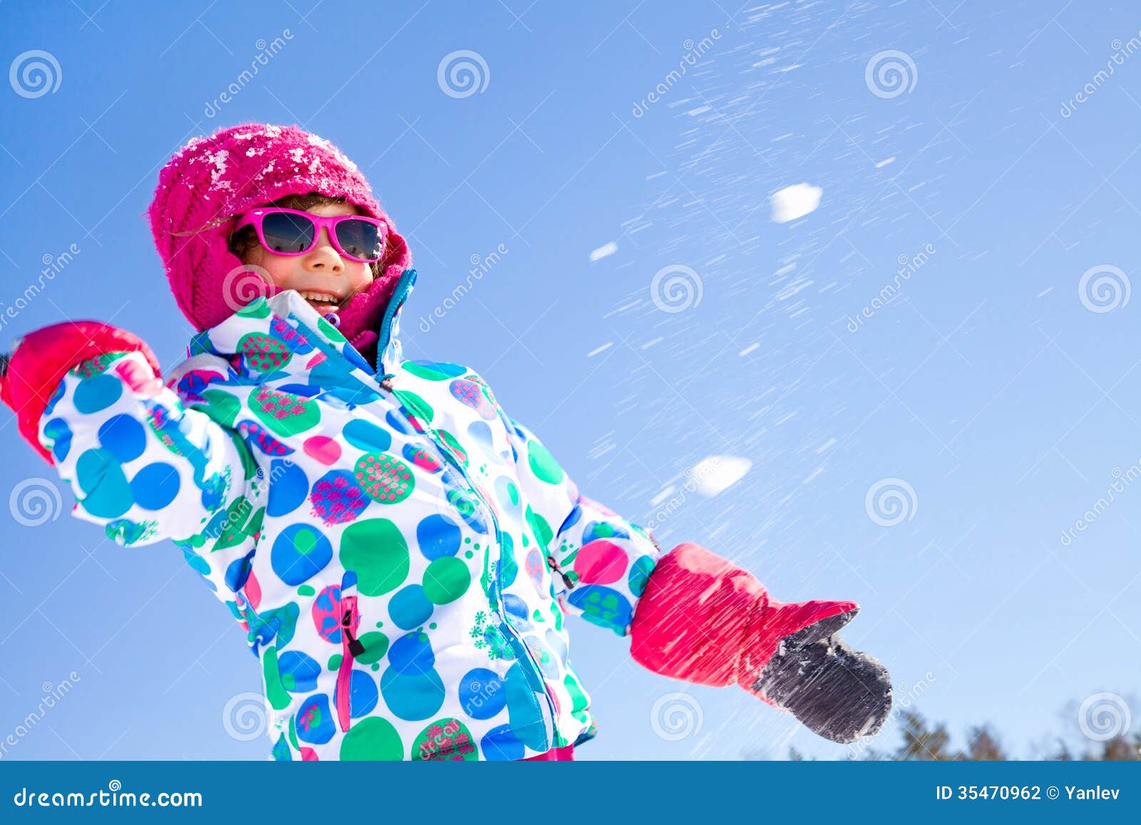 Winter playing. Little girl playing in snowballs in wintertime