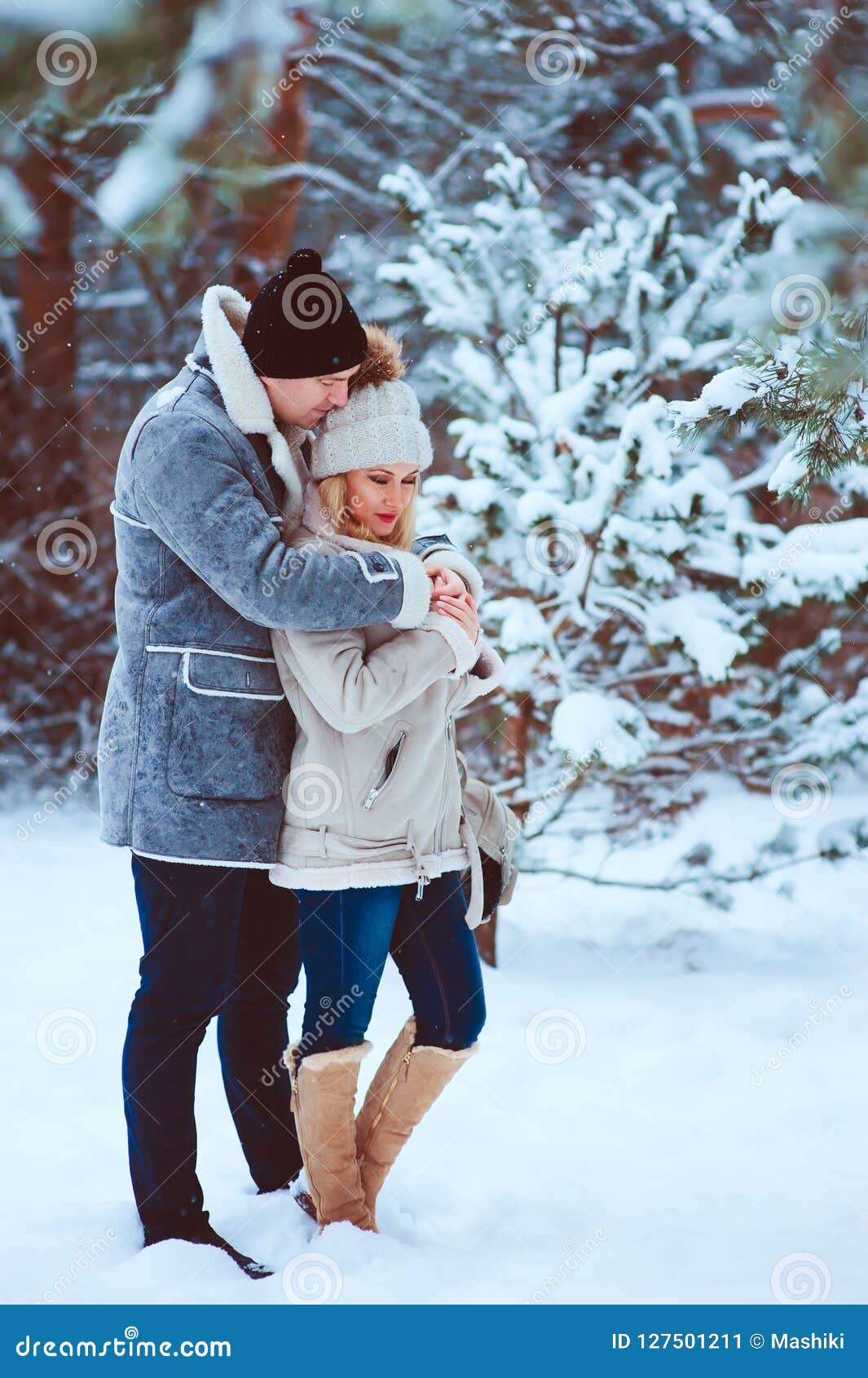 Winter Portrait Of Happy Romantic Couple Warm Up Each Other On The Walk In Snowy Forest Stock