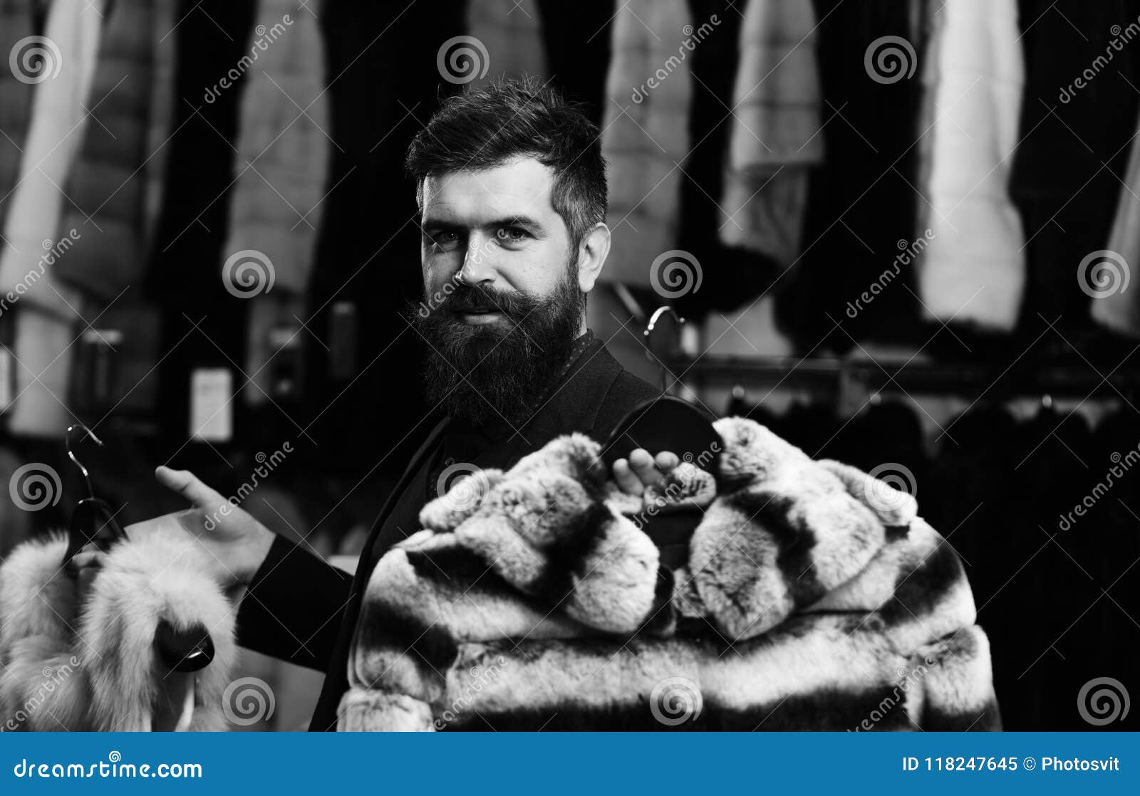 Winter Sale. Guy with Beard Chooses Furry Coats. Shop Assistant with ...