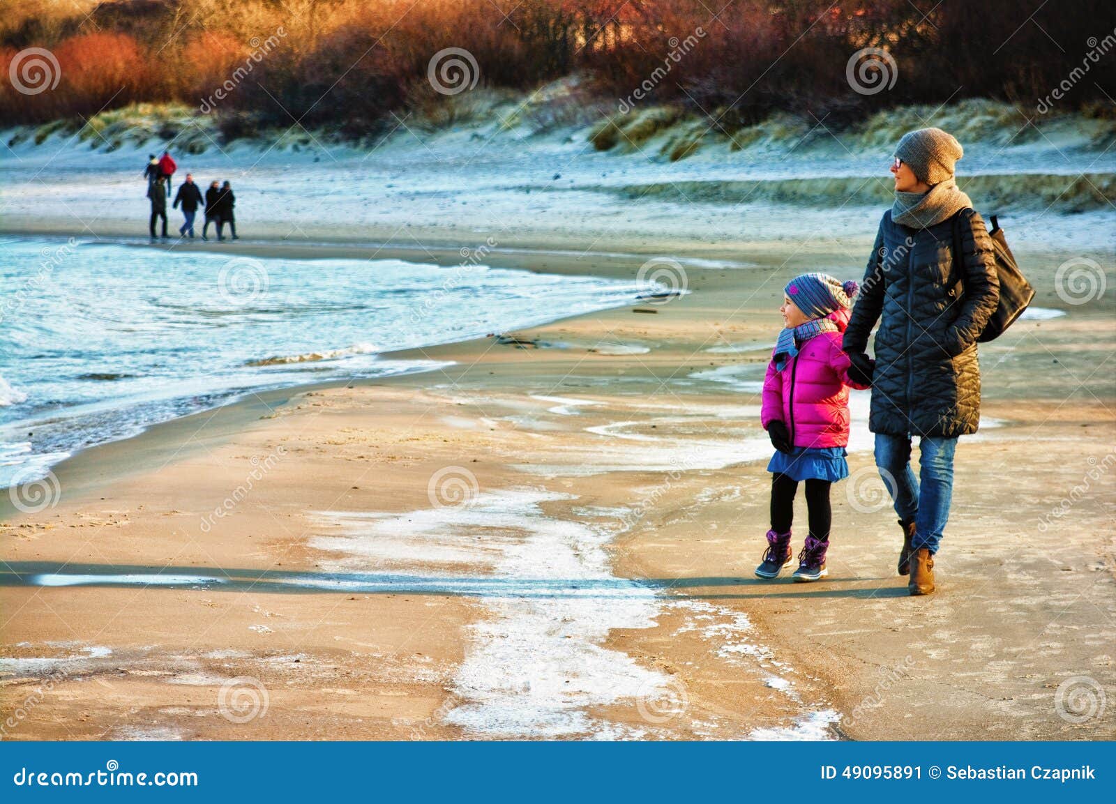 winter walk by baltic sea, mother and daughter