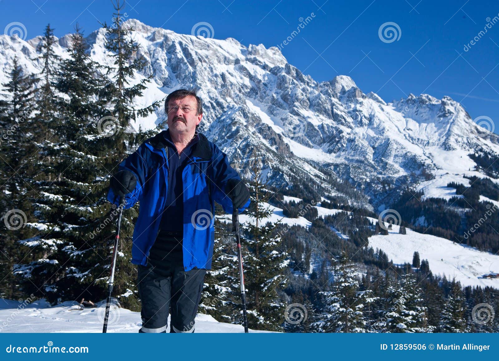 Wintertime. An active senior man with snowshoes in a winter setting in the alps.