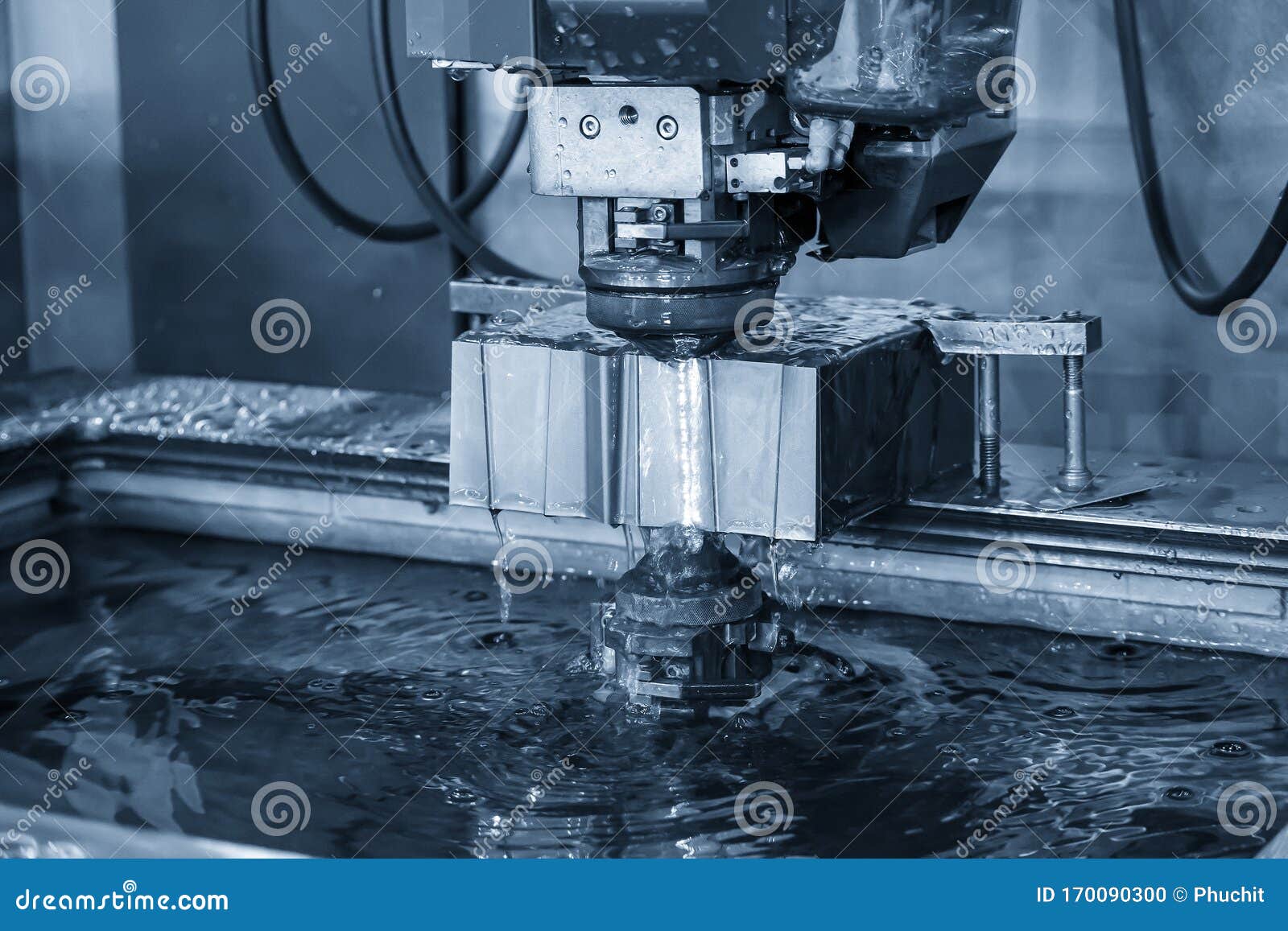 the  wire edm machine cutting the die parts with liquid coolant.