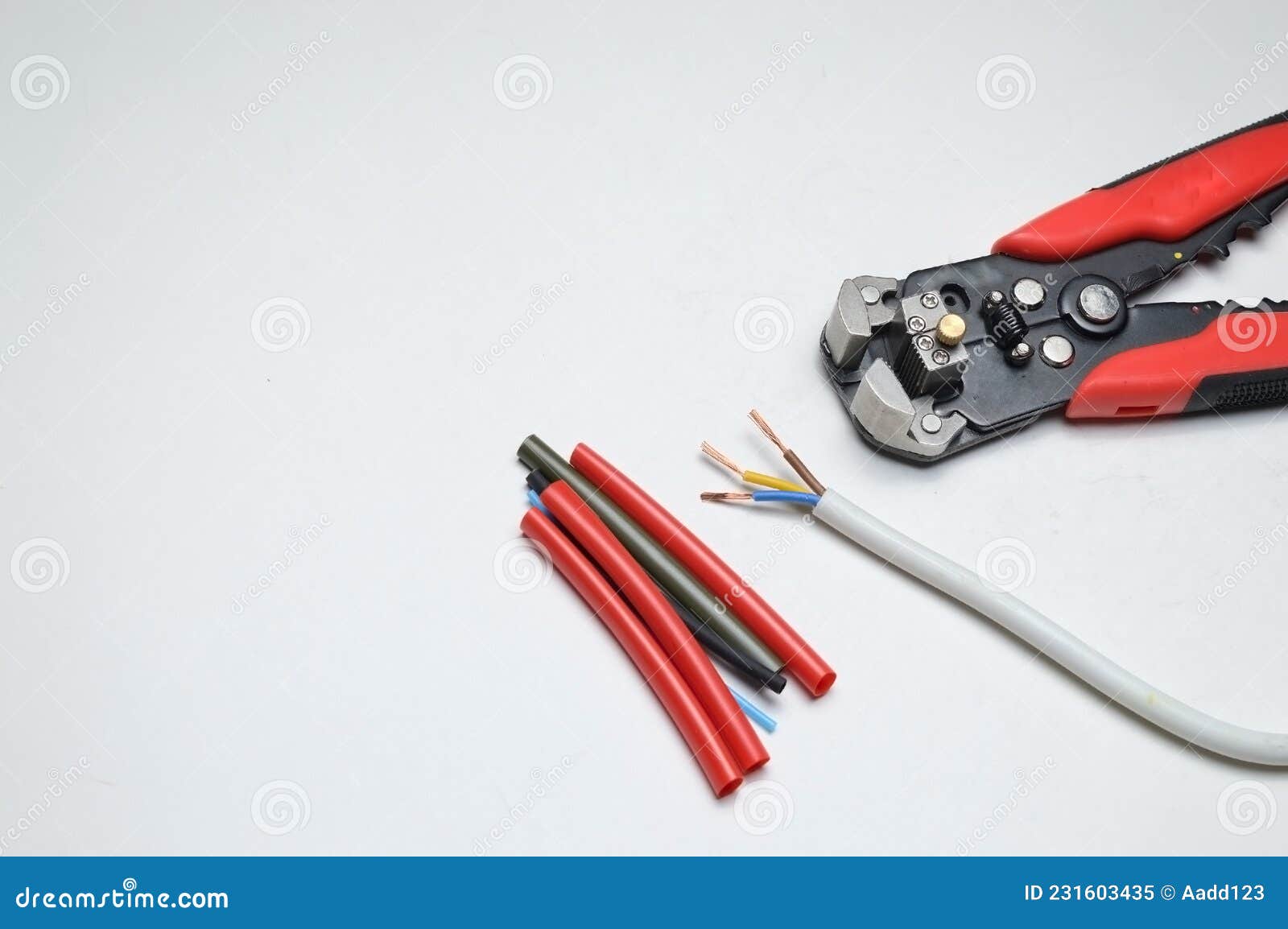 wire stripper, shielded three-core wire and heat shrink tubing on a white background. close-up