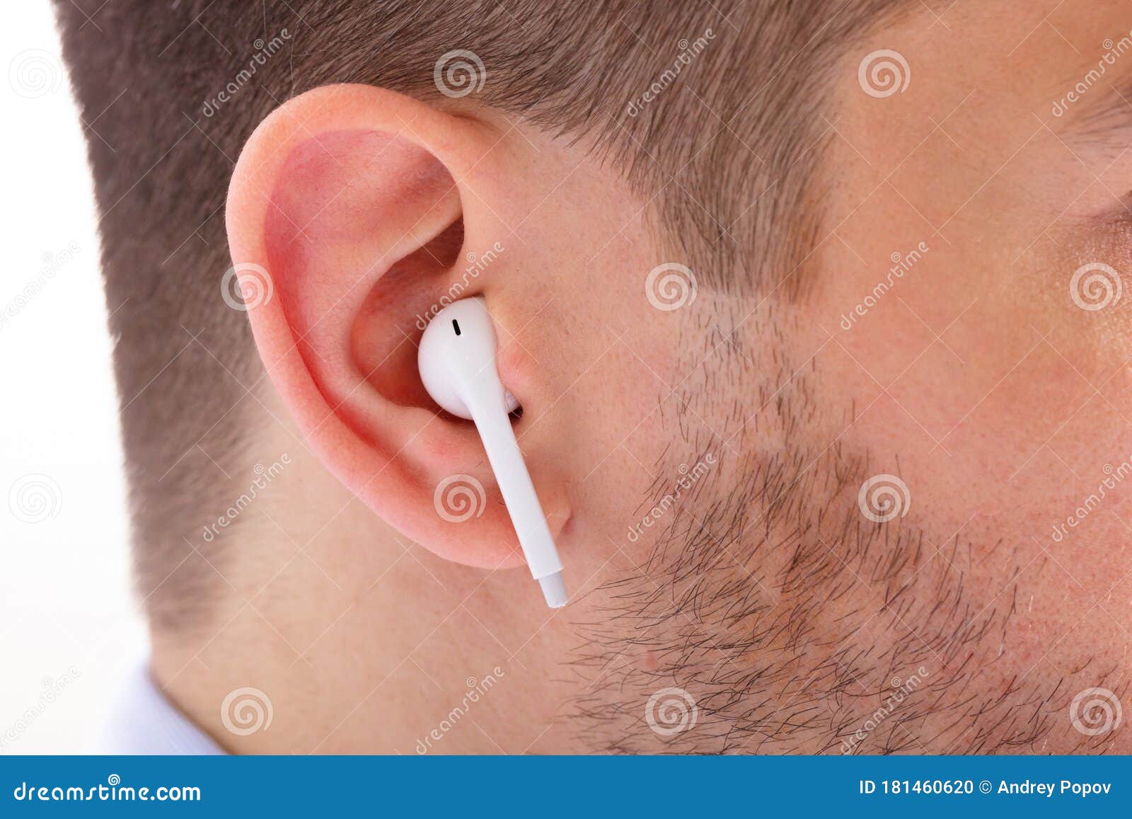 wireless earphone in man`s ear