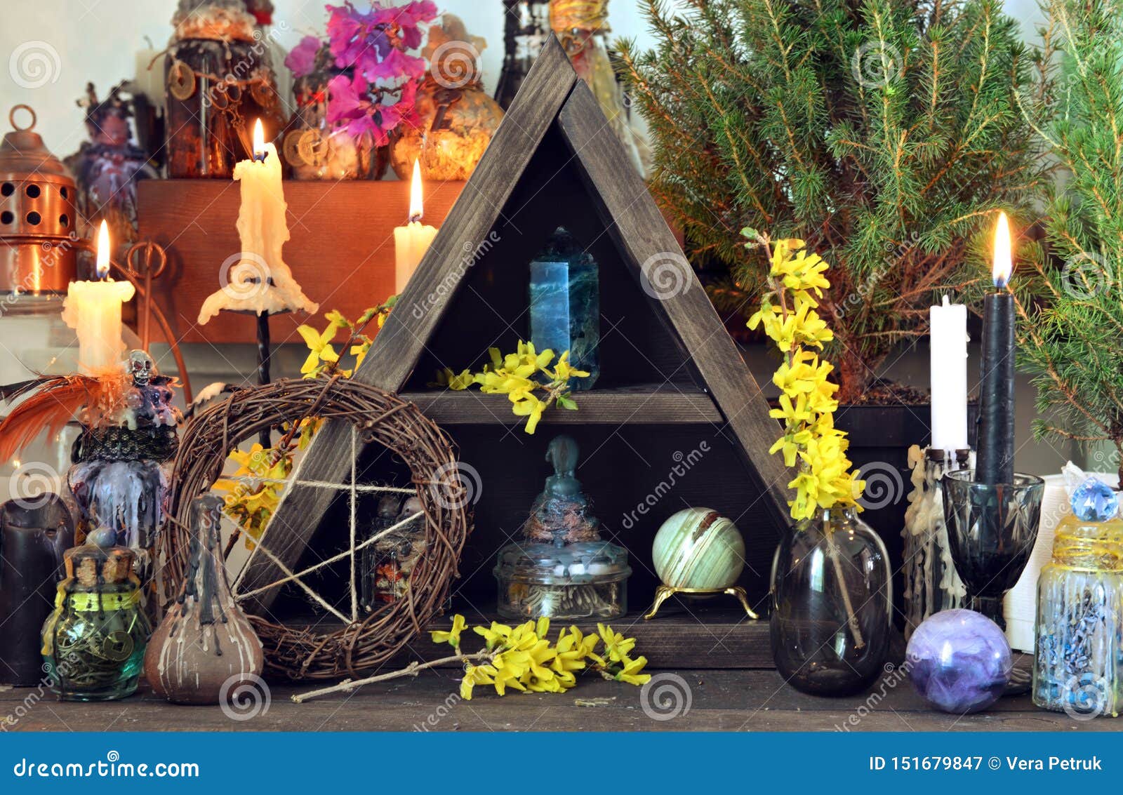 witch altar with pentagram, spring flowers, black candles