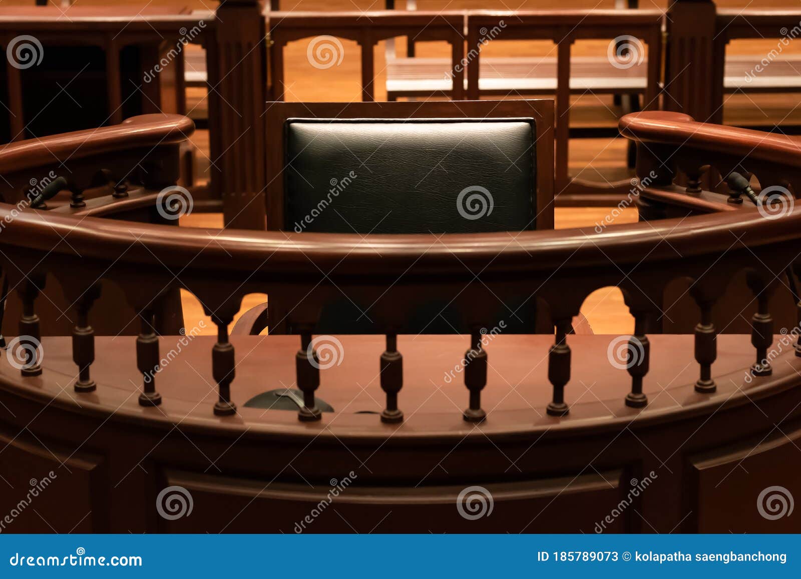 a witness stand with a black seat in the court room infront of tribunal when witness testify of evidence to judge, they will sit a