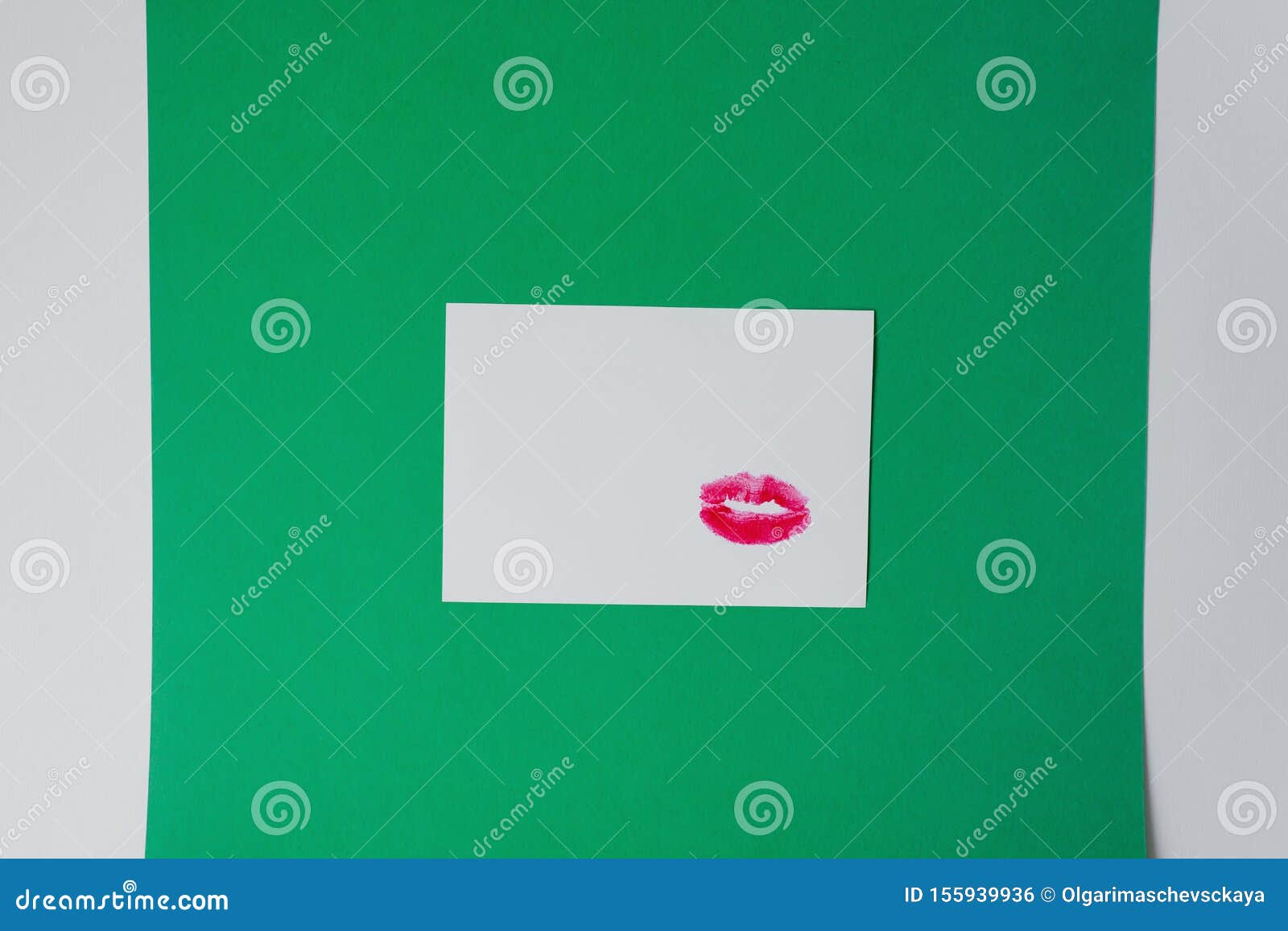 Witte kaart met lippenafdruk, lipstick op wit papier op groene en witte achtergrond Kopieerruimte Een kus op de brief