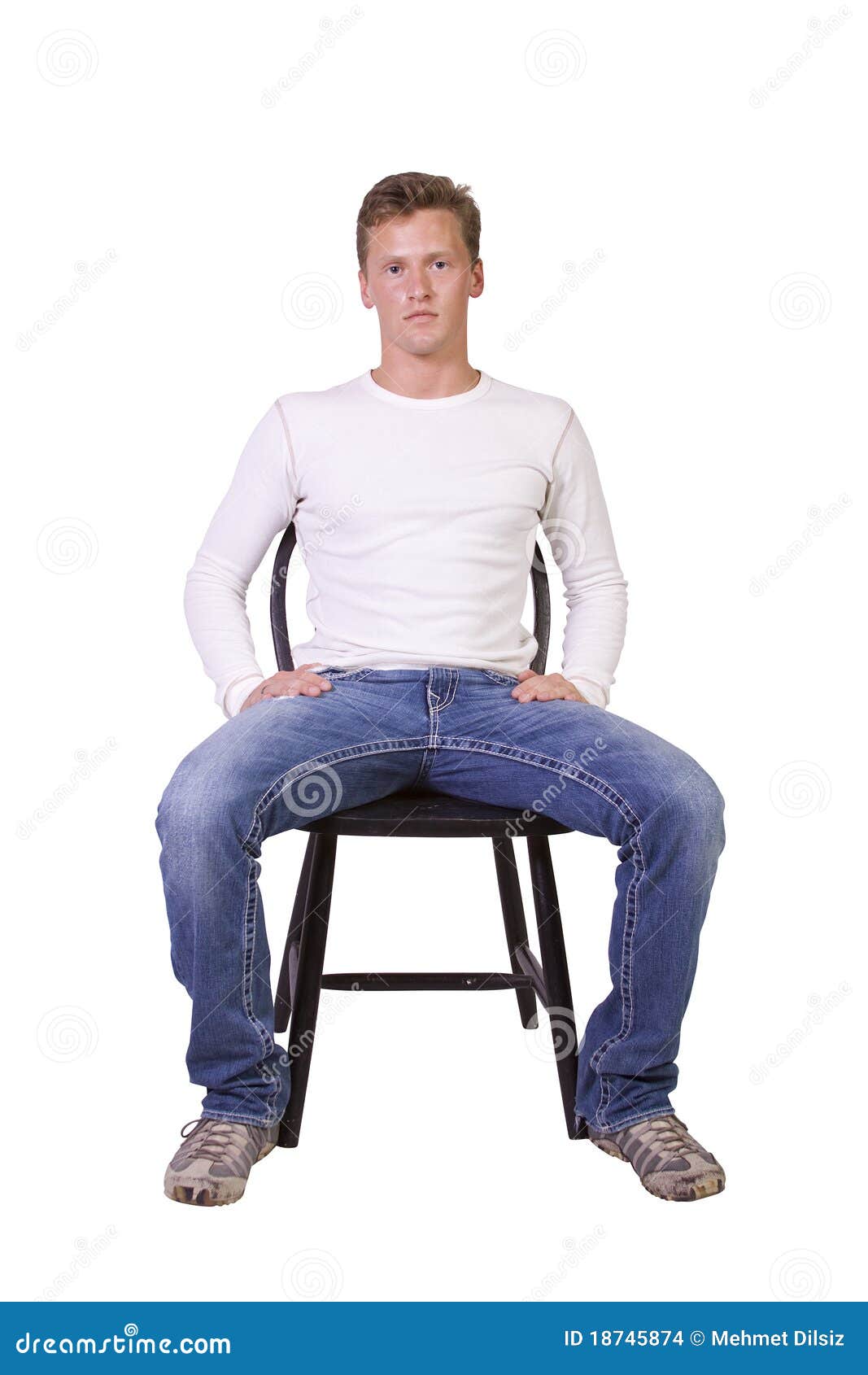 Мужчина сидит расставив ноги