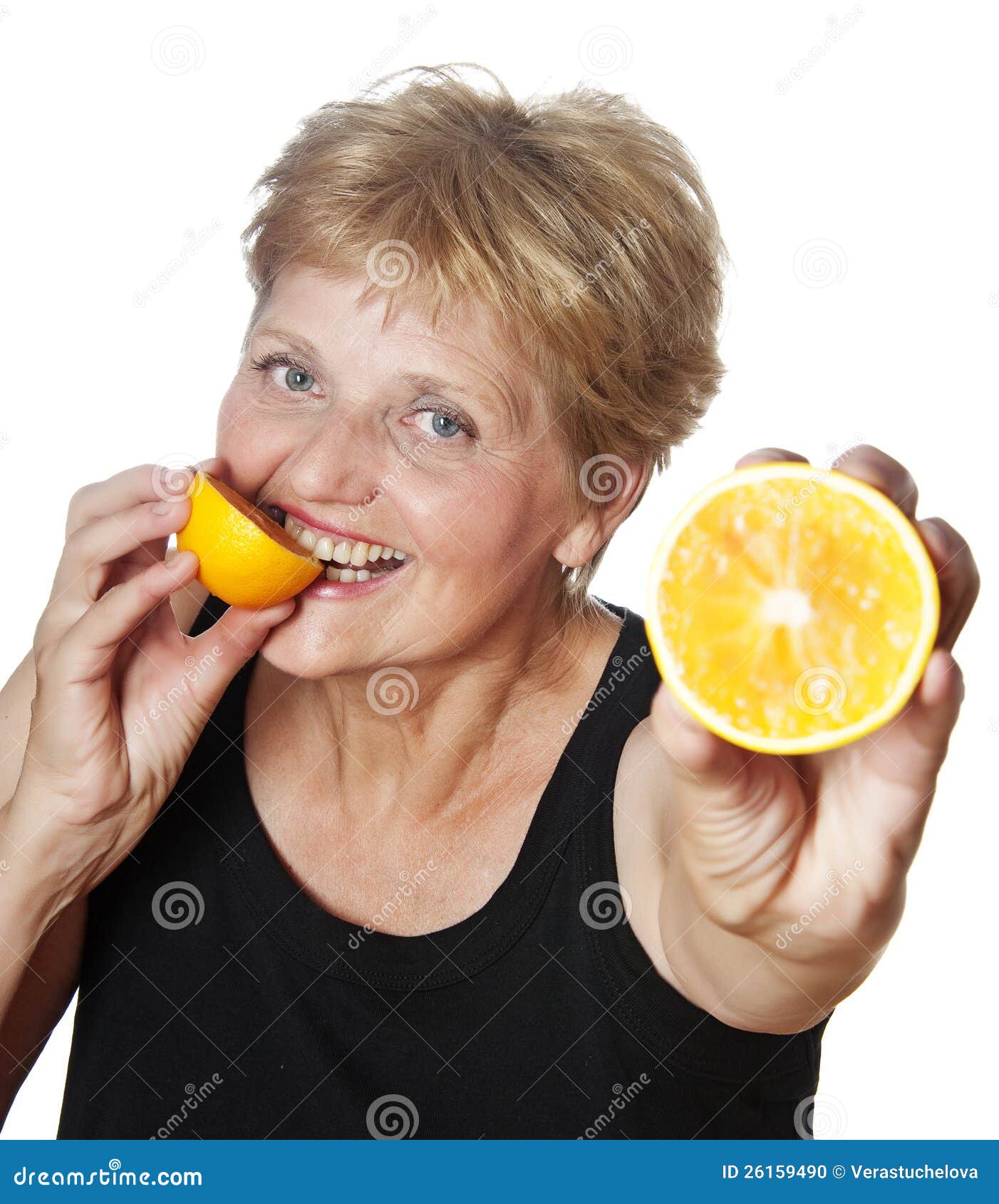 Woman (67 years old) eating orange - health concept