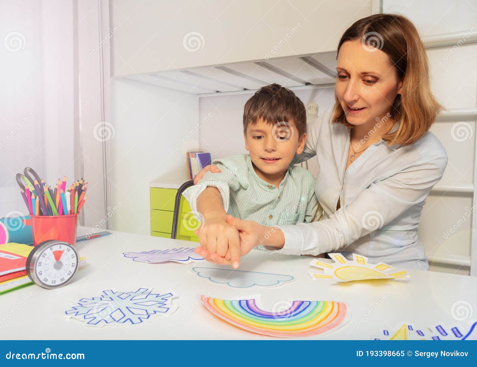 woman during aba therapy teach boy weather cards