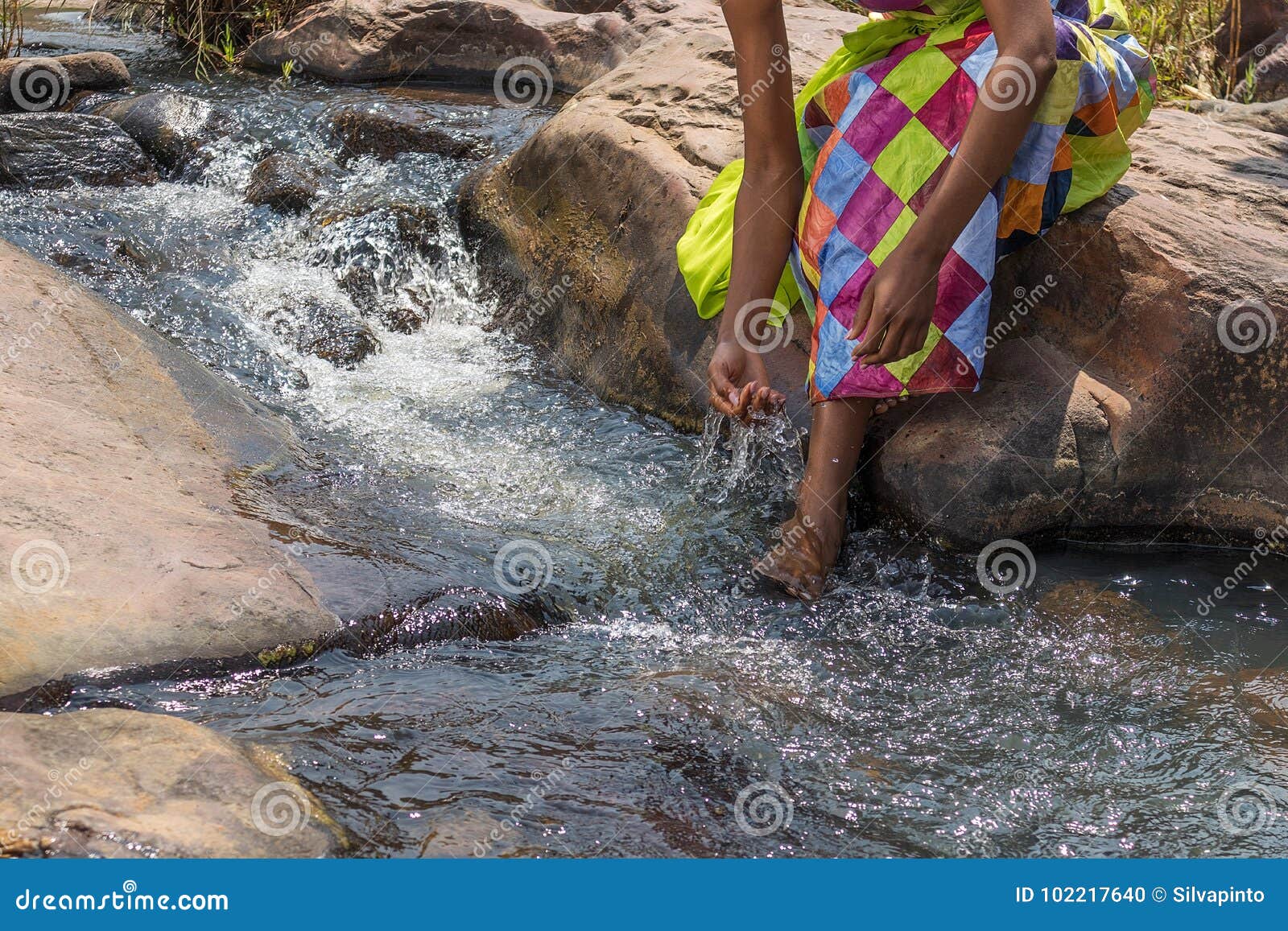 Woman in African Outfit on the Verge of Fluent River. Interacting with