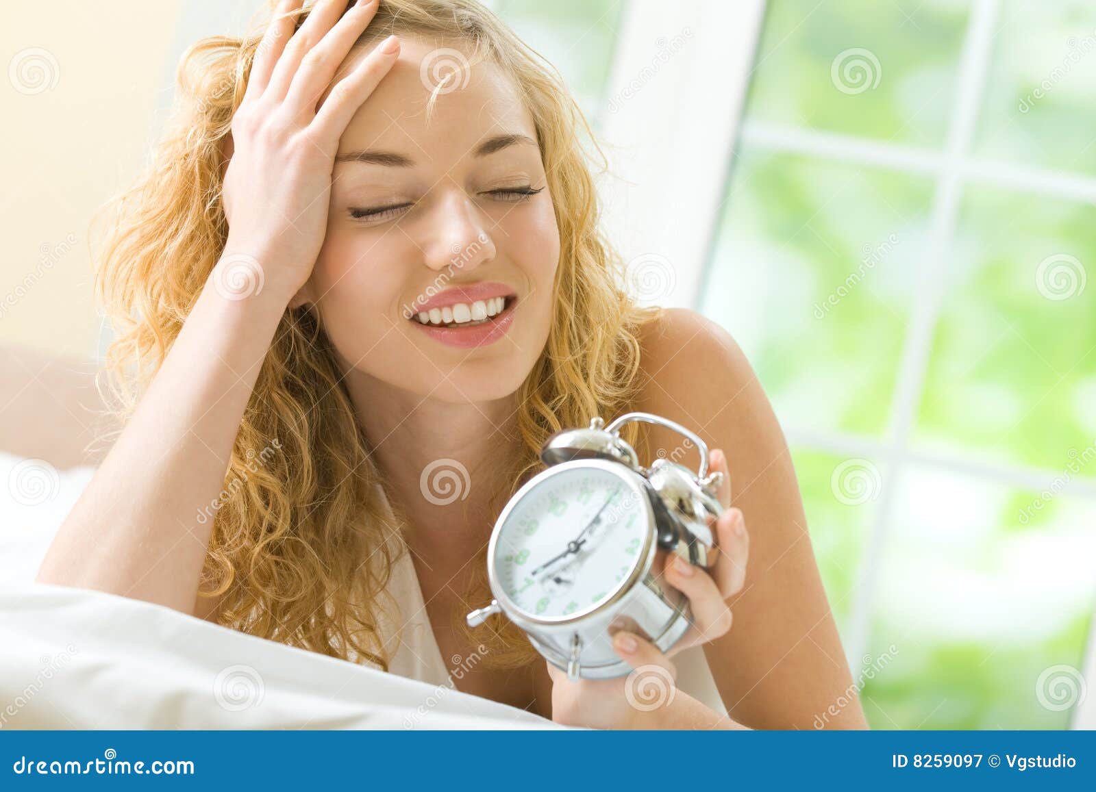 Woman with alarmclock stock image. Image of interior 8259097