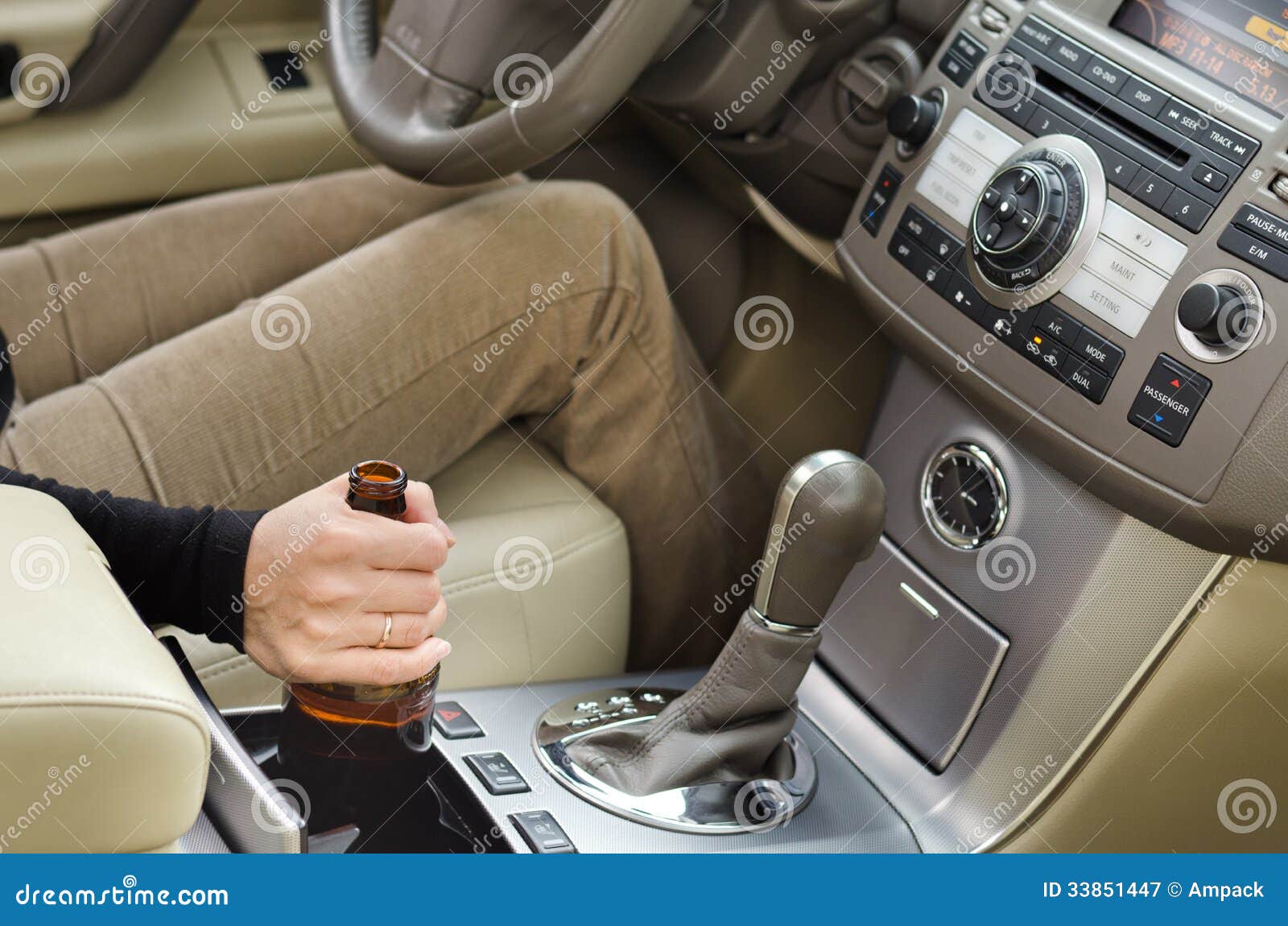 woman alcoholic with a bottle of booze in the car