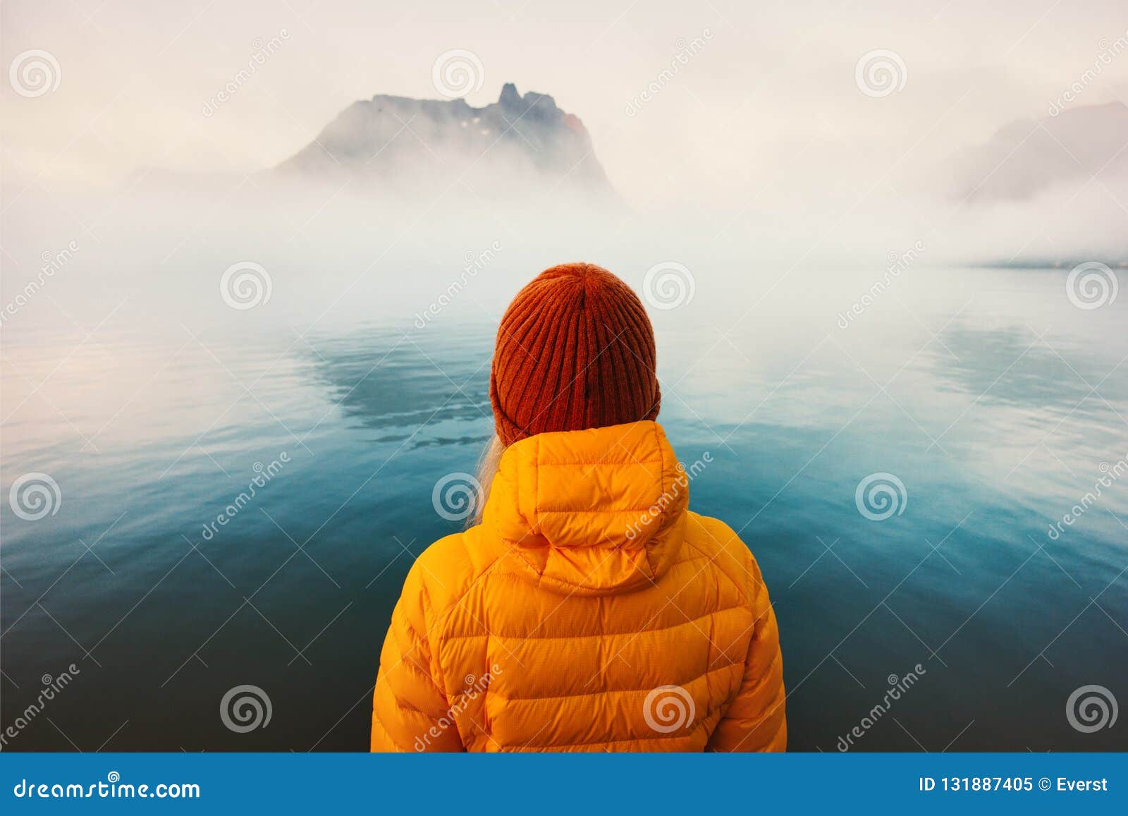 woman alone looking at foggy cold sea traveling adventure lifestyle