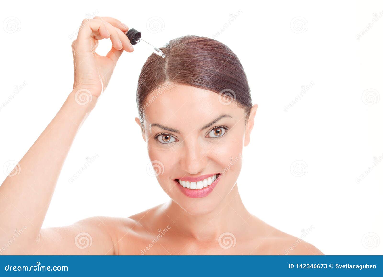 woman aplying serum essence, essential oils to her hairline
