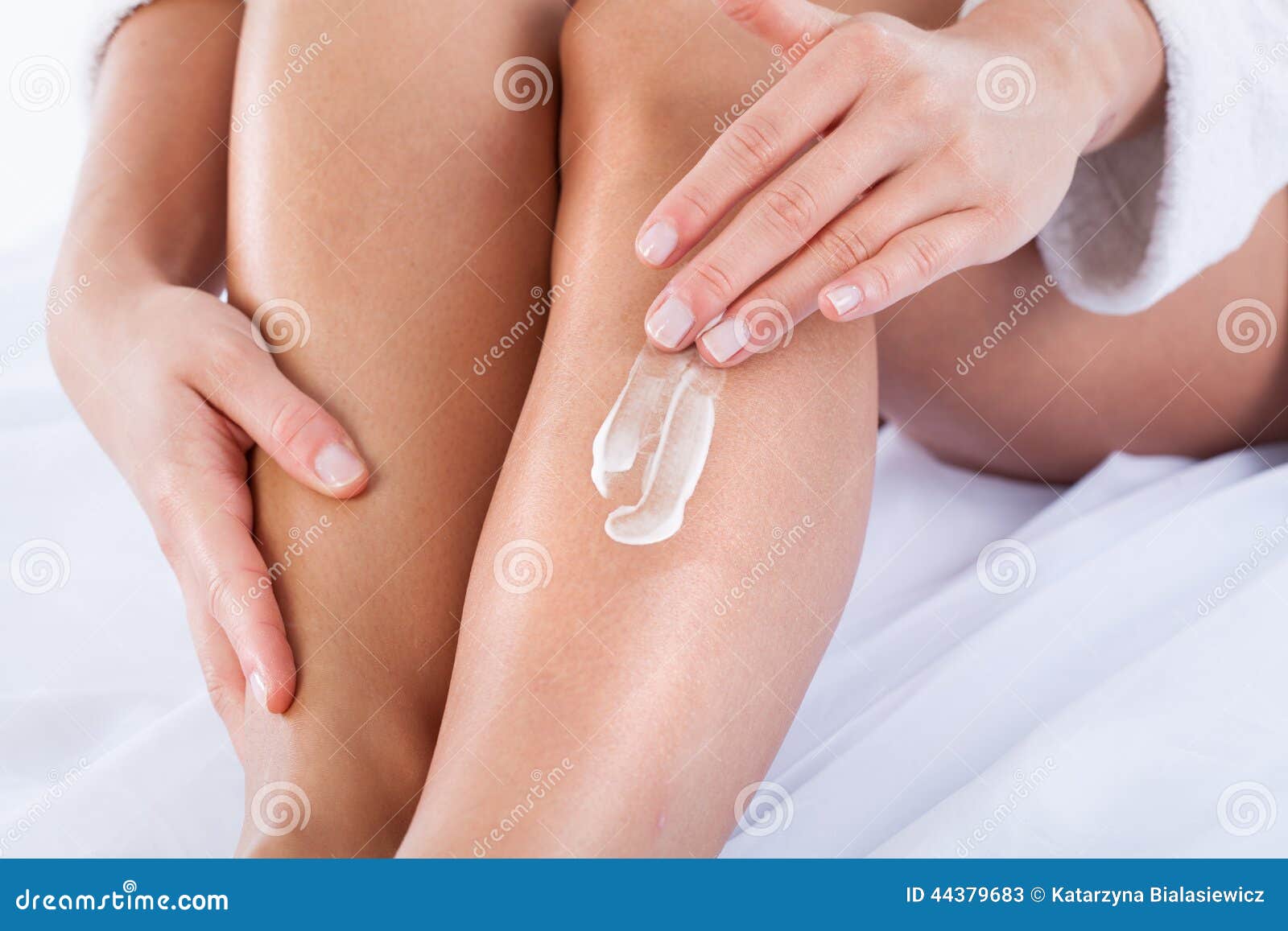 woman applying body lotion on skin