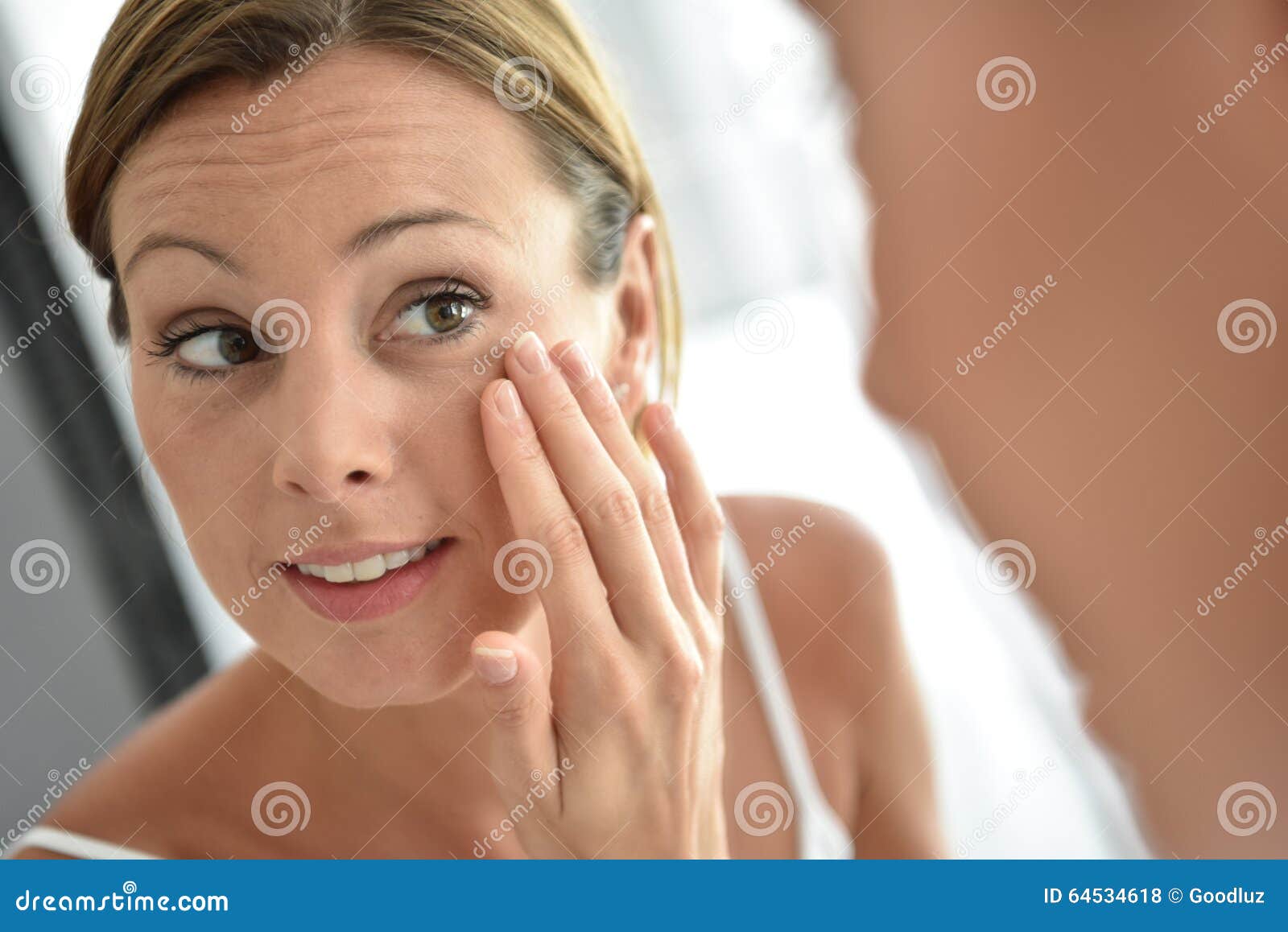 woman applying daily cream on her face