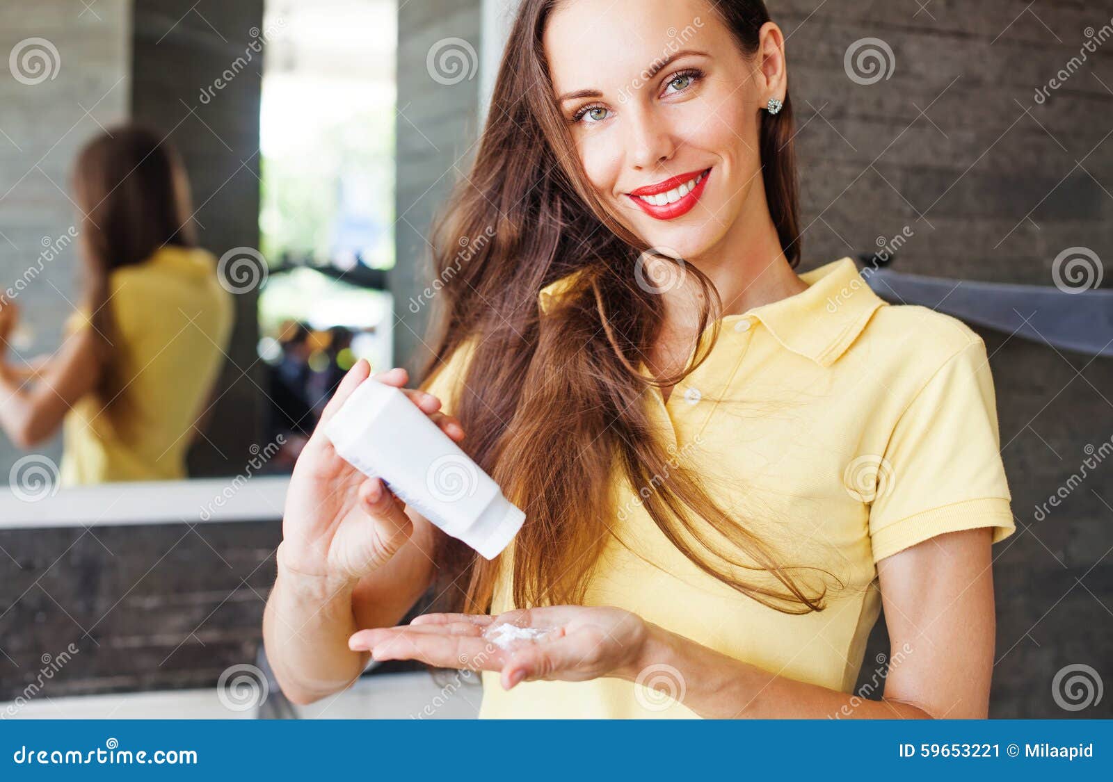 woman applying dry shampoo on her hair