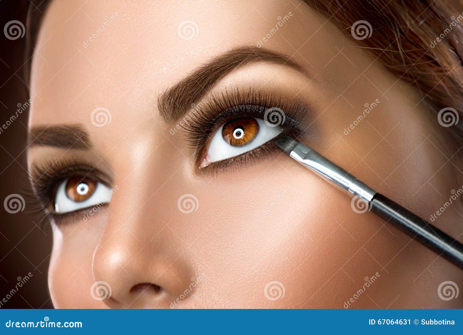 woman applying eye makeup closeup