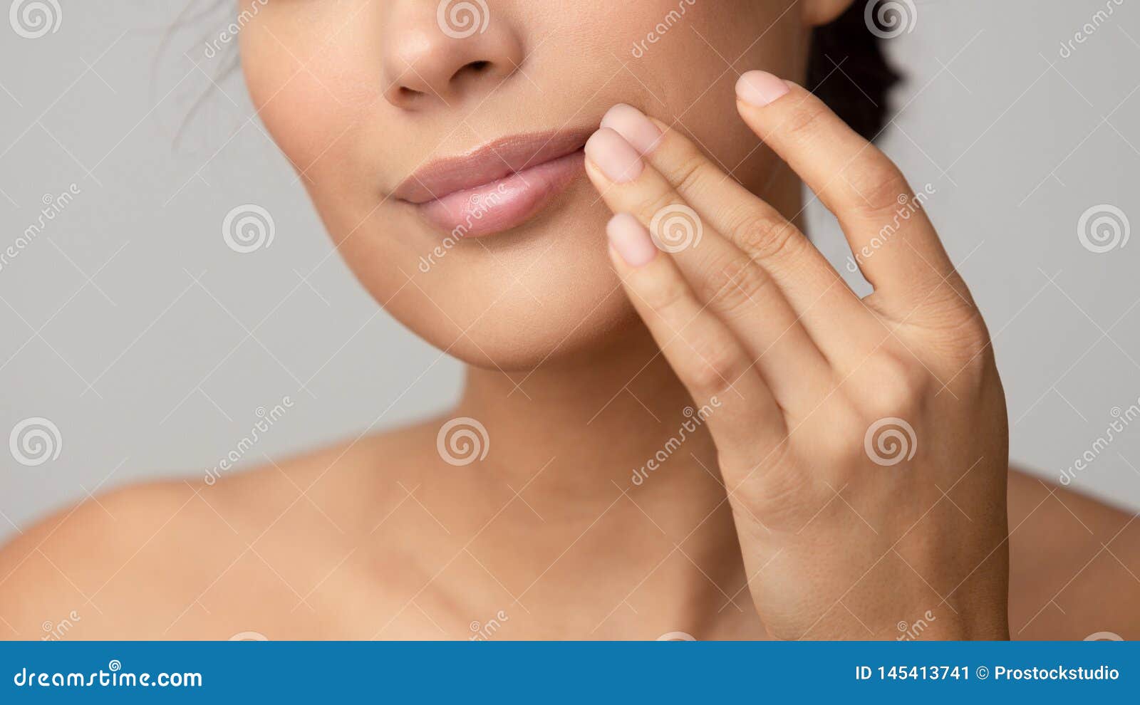woman applying lip balm over grey background