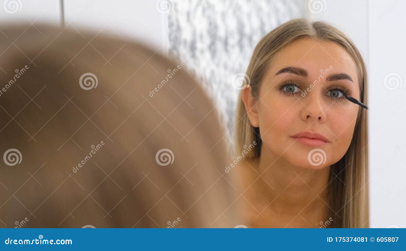 Woman Applying Make Up in Front of a Mirror. Stock Image Image of