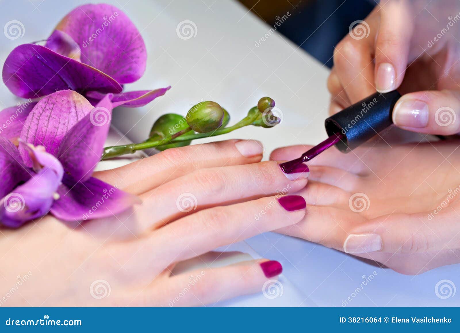 woman applying nail varnish to finger nails