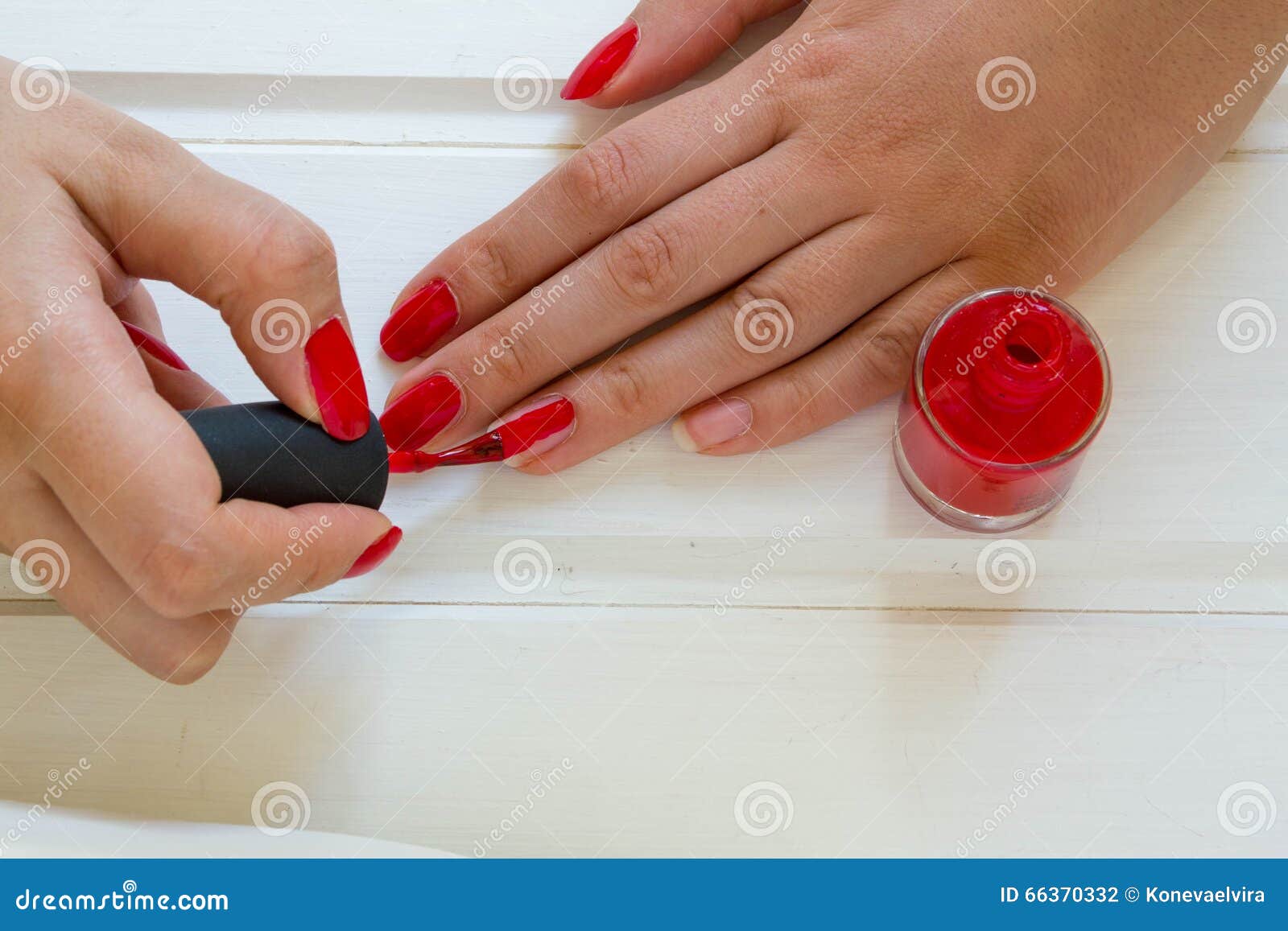 woman applying red nail polish manicure. female hand