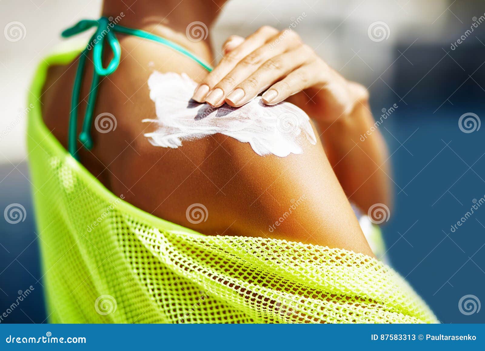 woman applying sunscreen on her shoulder