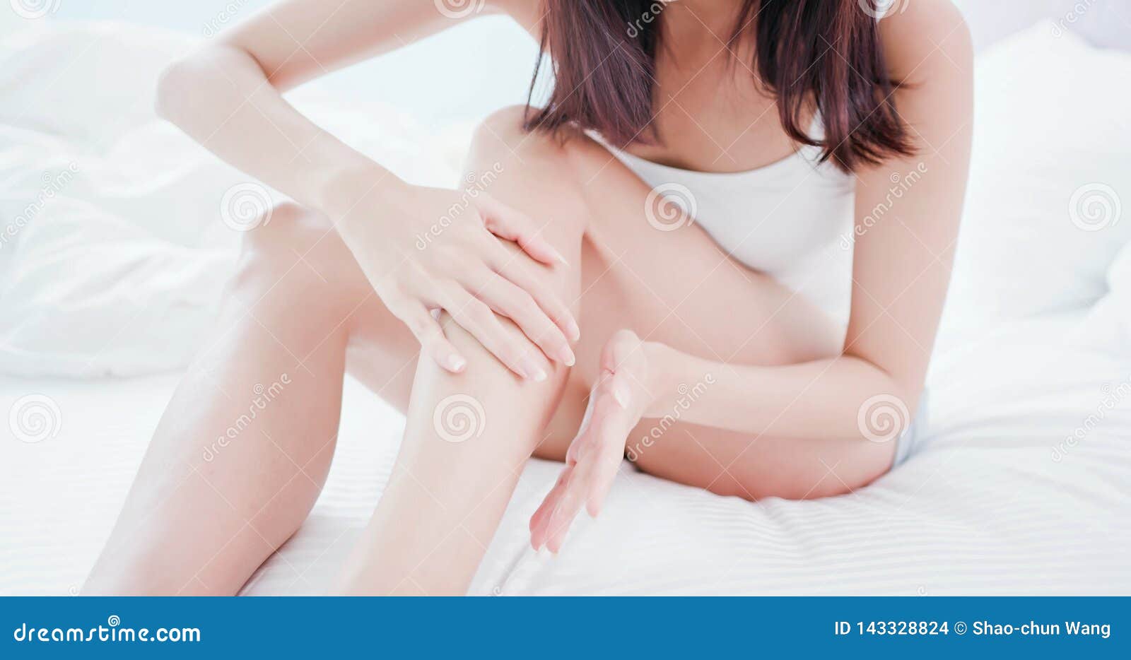 woman applying cream onto leg