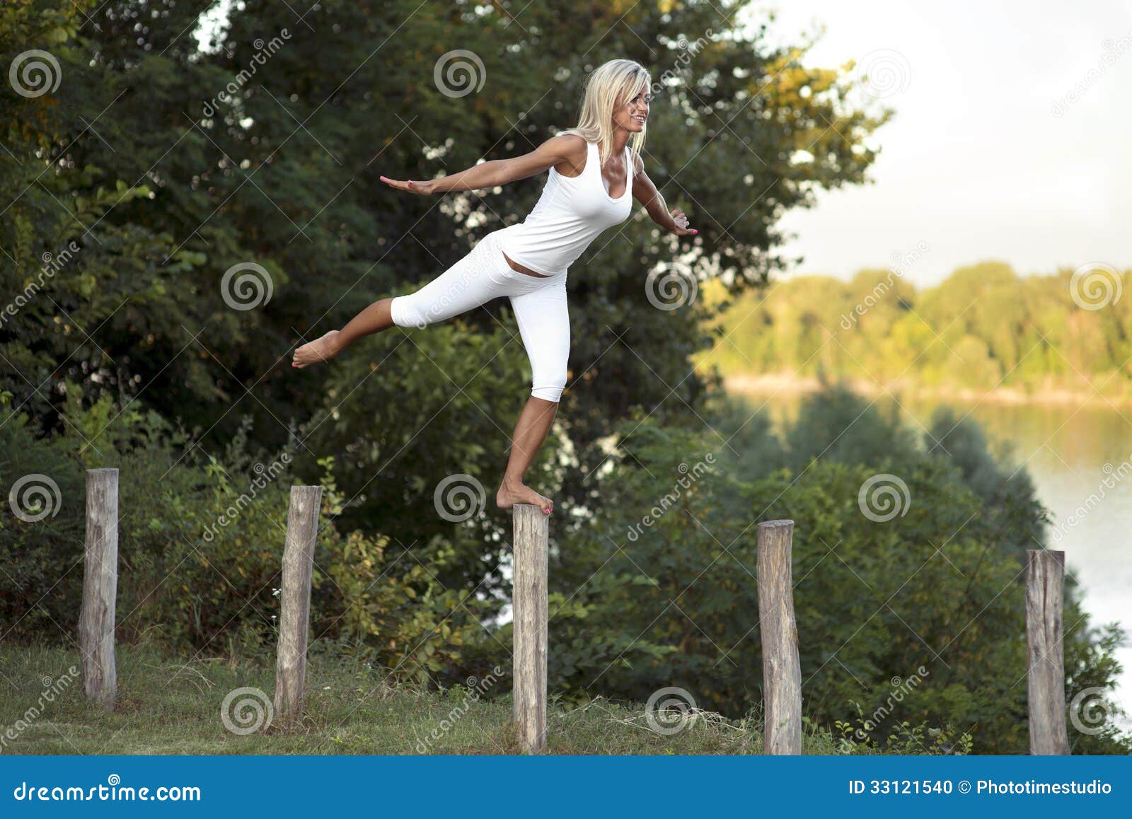 woman balancing on fence post