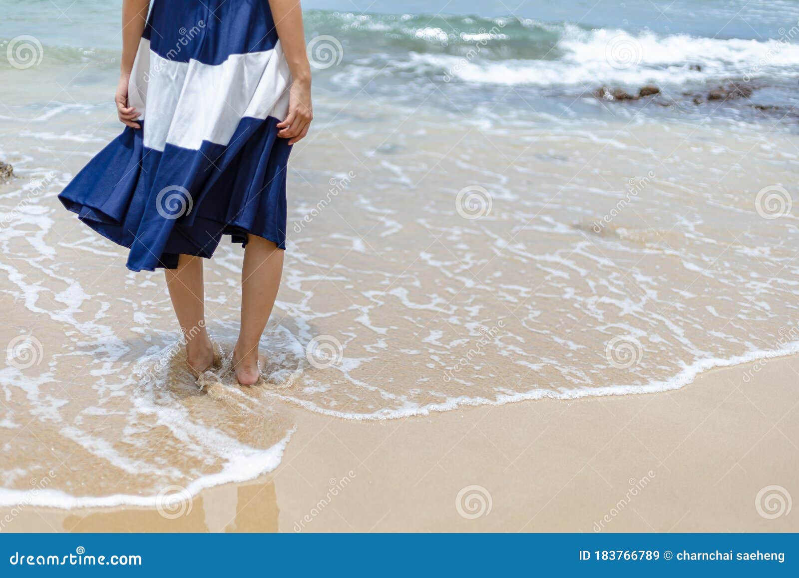 Back View Of A Woman Walking Barefoot On A Caribbean Beach 