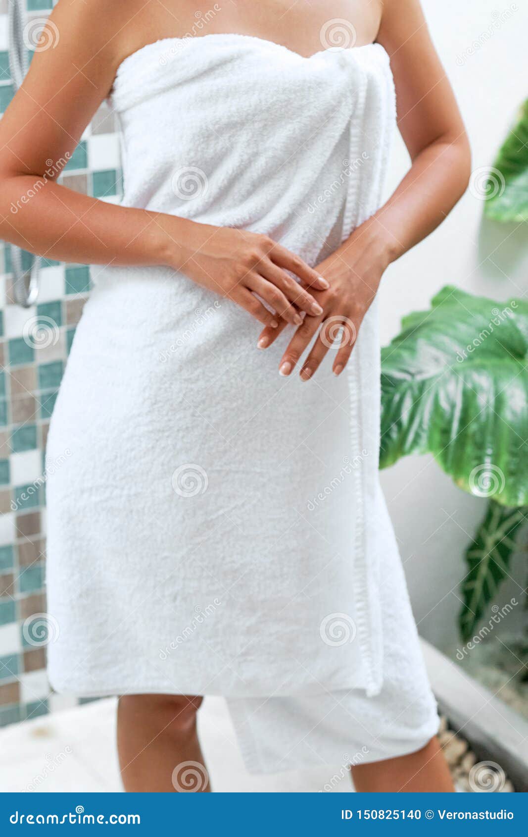 A Woman in a Bath with Towel. Girl Shows Hands in Form Heart