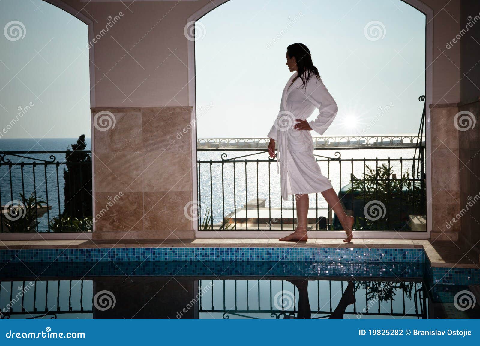 Woman in bathrobe at pool stock photo. Image of columns 19825282