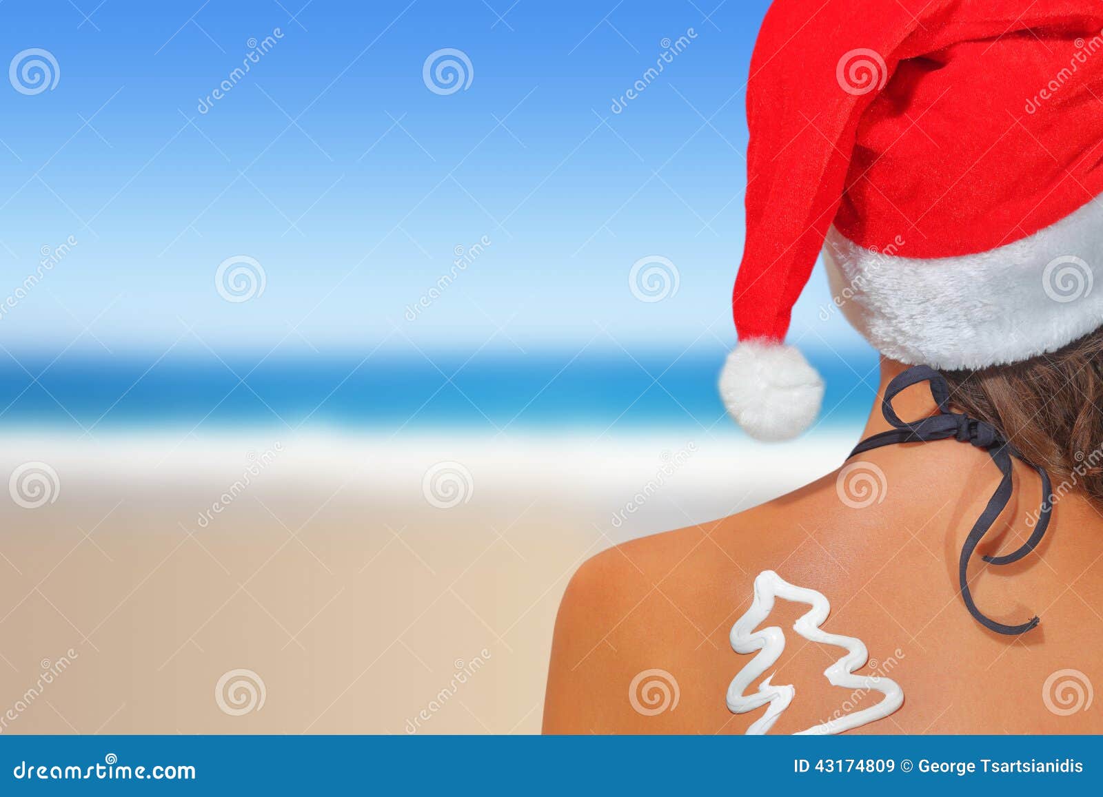 woman on the beach in santas hat