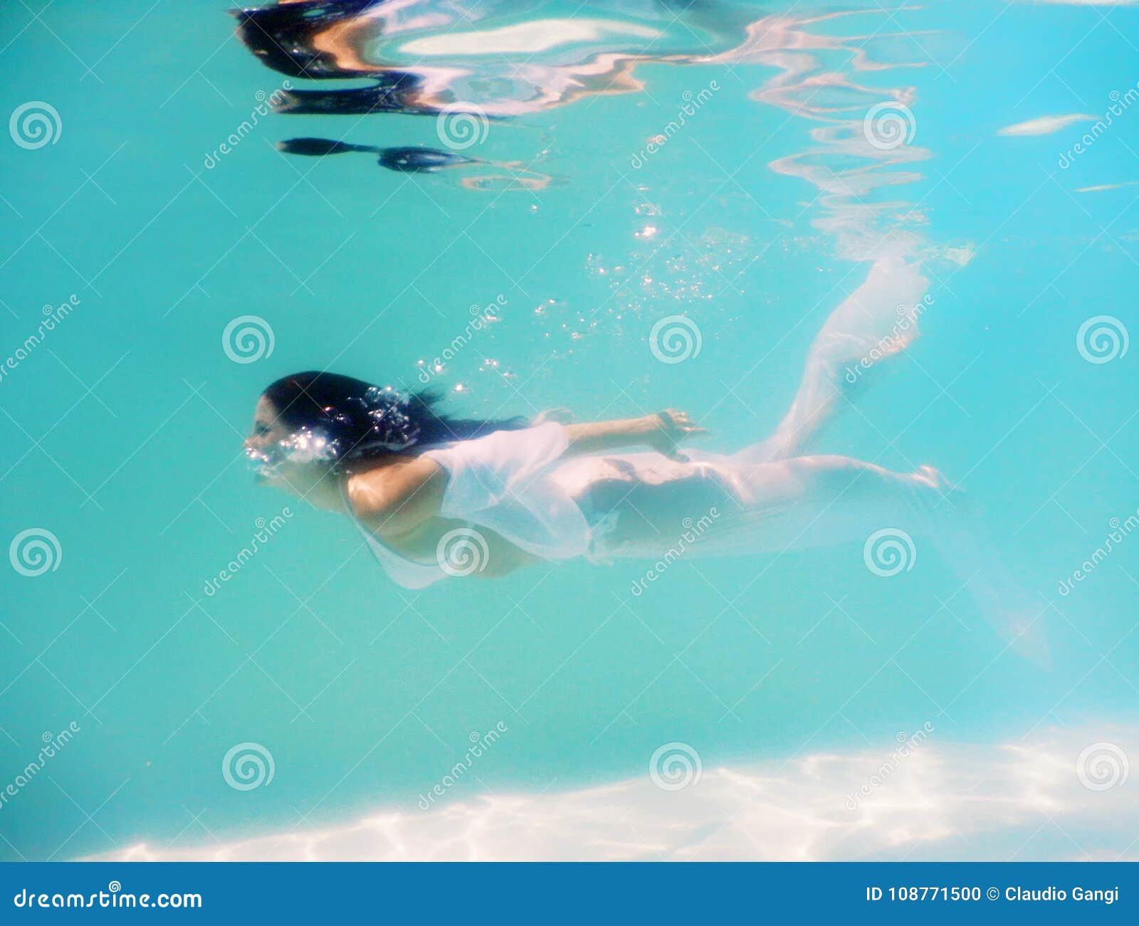 Woman beautiful body swim underwater in white dress-