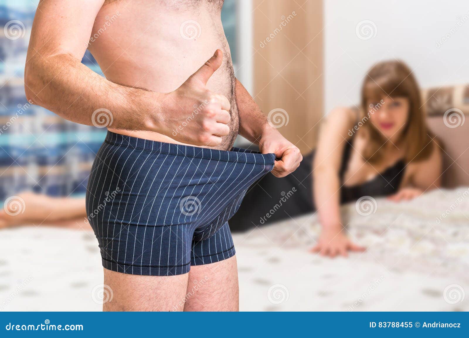 Woman in Bed and Man in Underwear Showing Thumb Up Stock Image