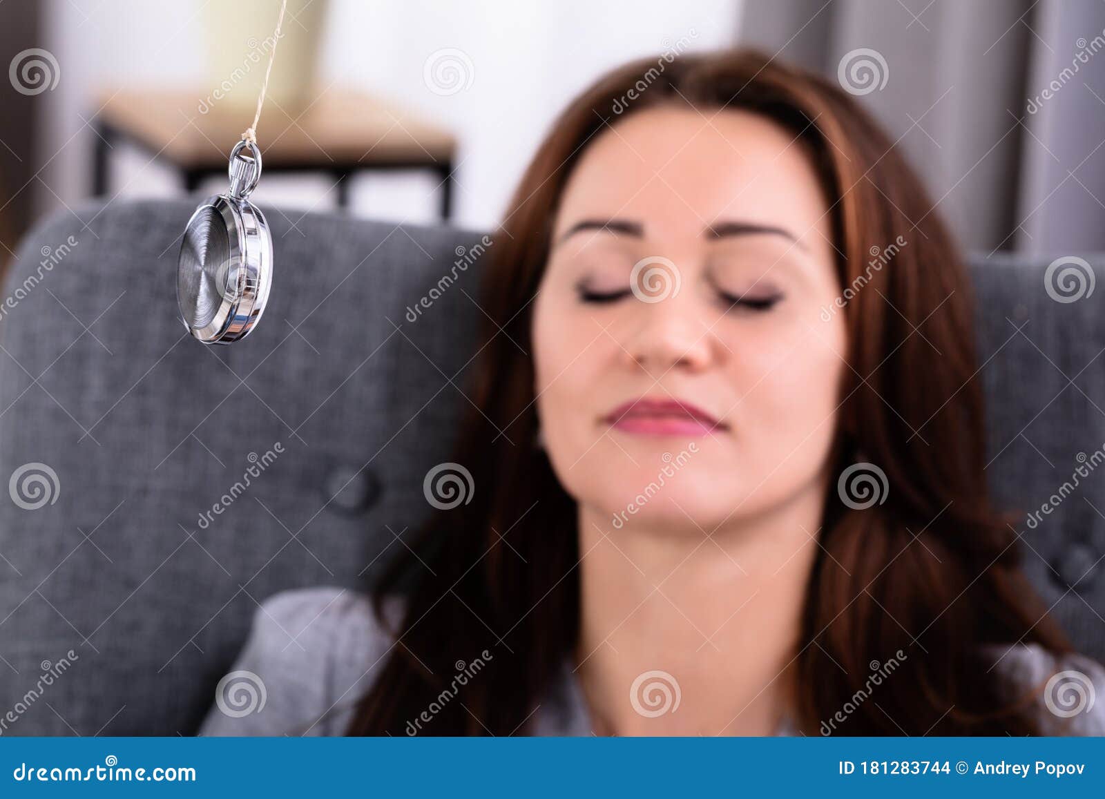 woman being hypnotized while sitting on sofa