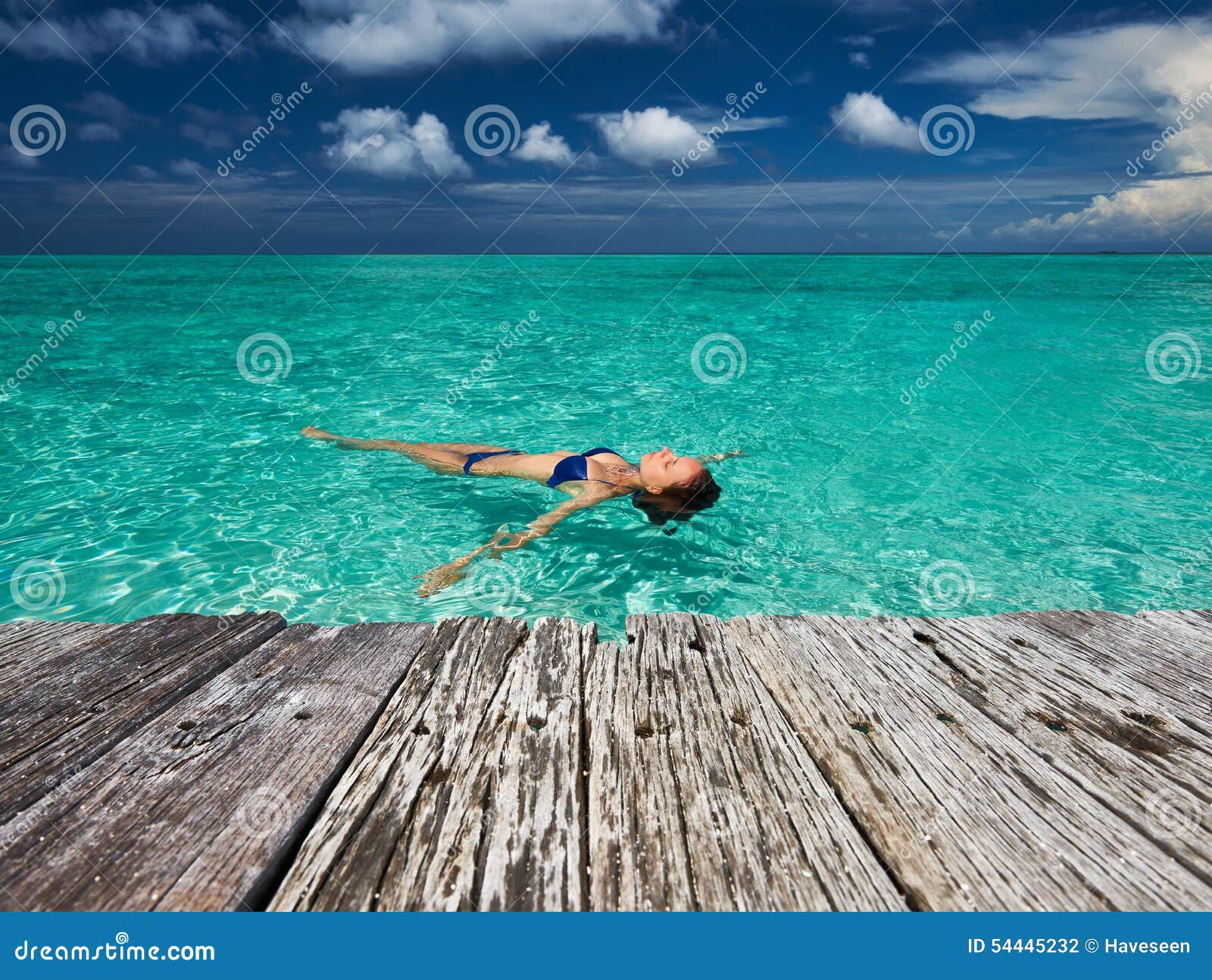 Teen Girl Laying On A Dock In Her Bikini by Stocksy Contributor