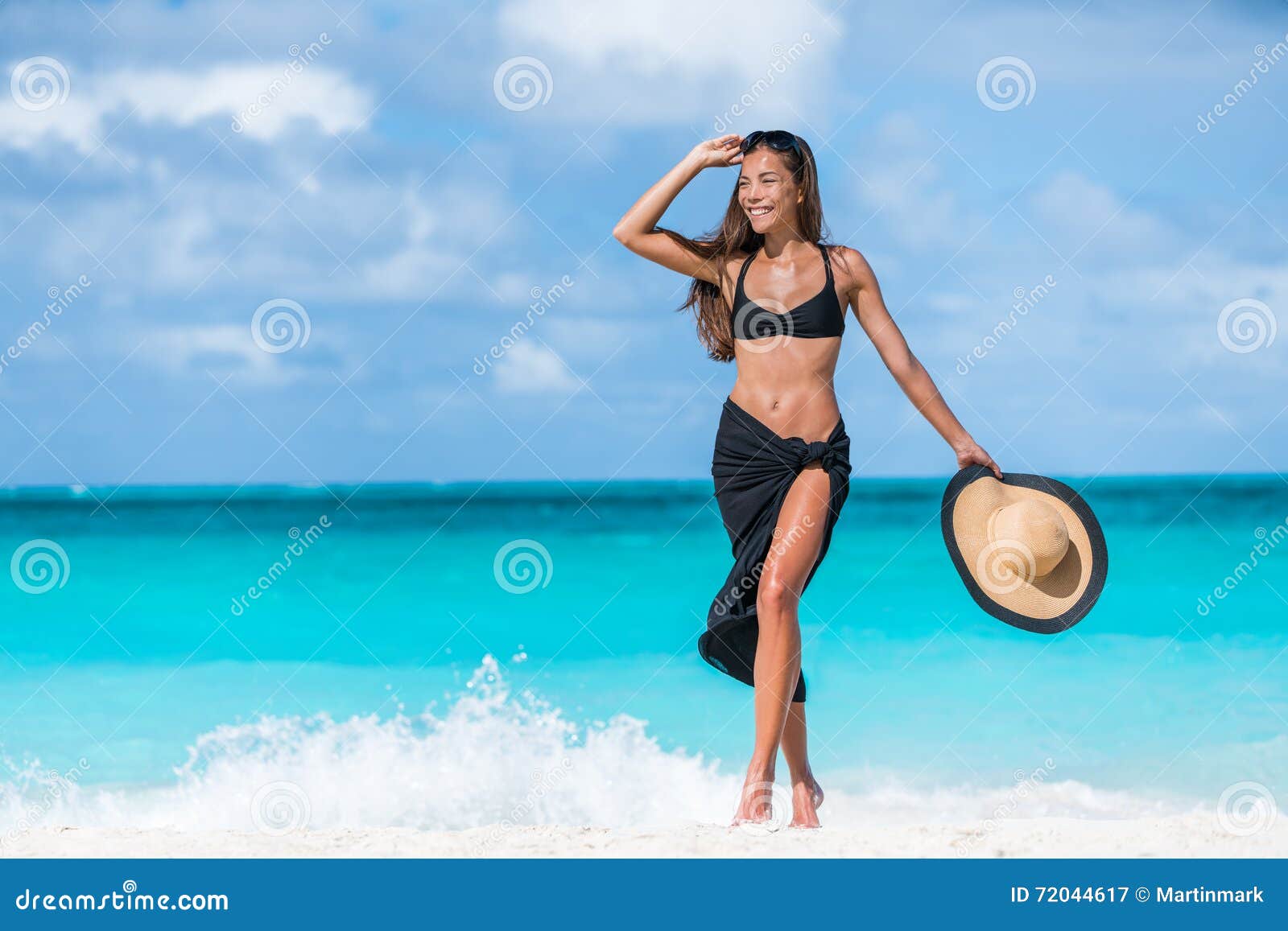 Woman walking on beach in blue fashion beachwear bathing suit and