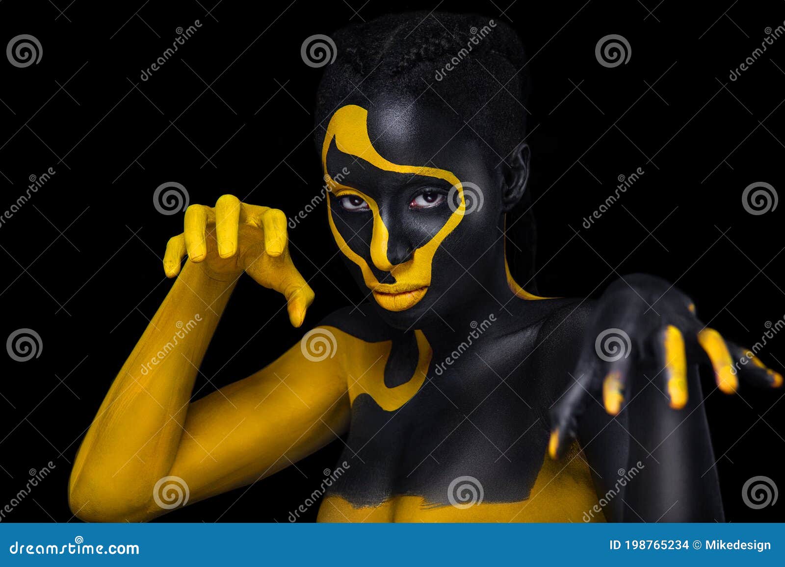 Yellow and black body paint. Woman with face art. Young girl with colorful  bodypaint. An amazing afro american model with makeup. Stock Photo