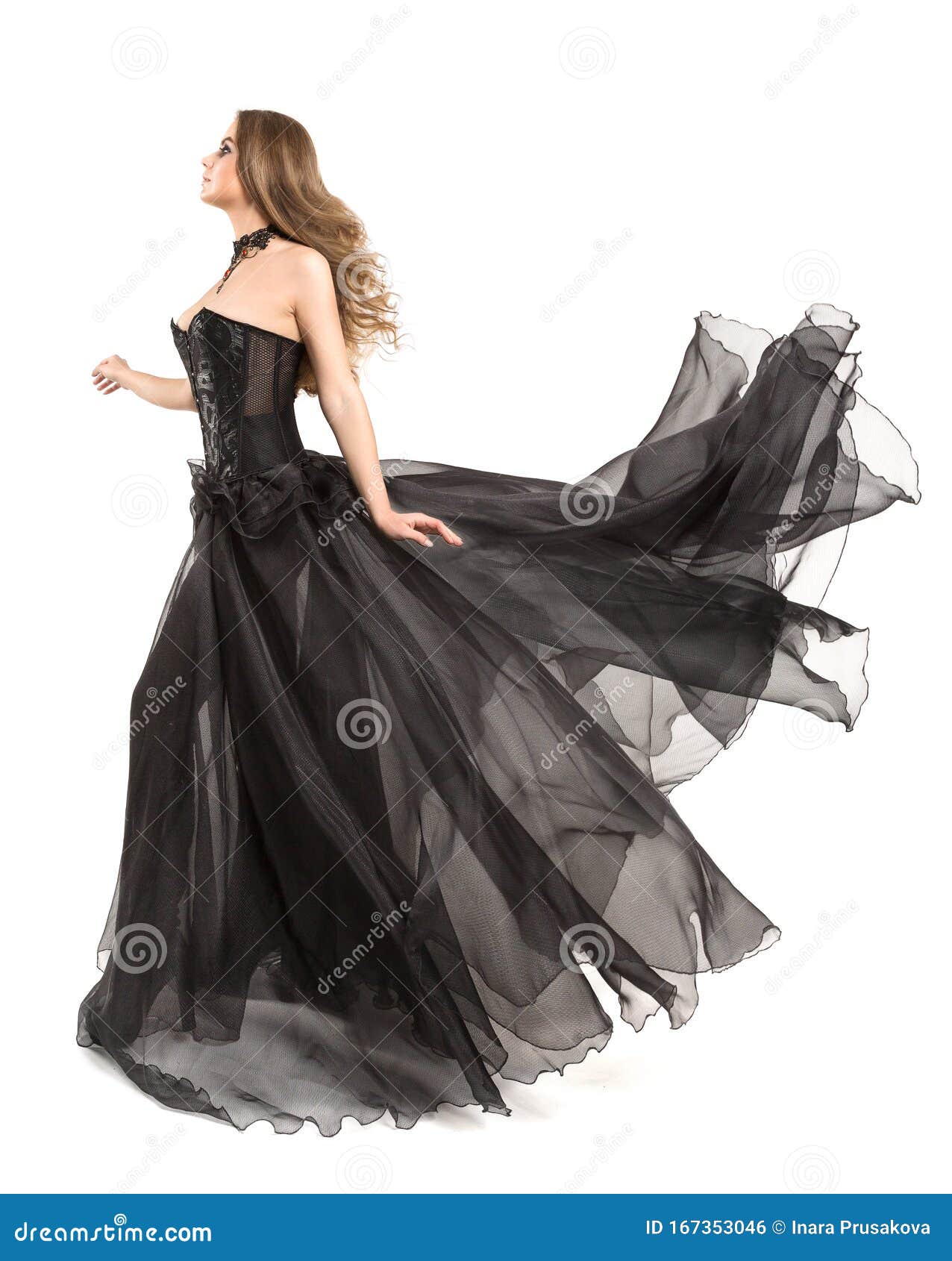 woman black dress flying on wind, beautiful fashion model in fluttering chiffon gown on white