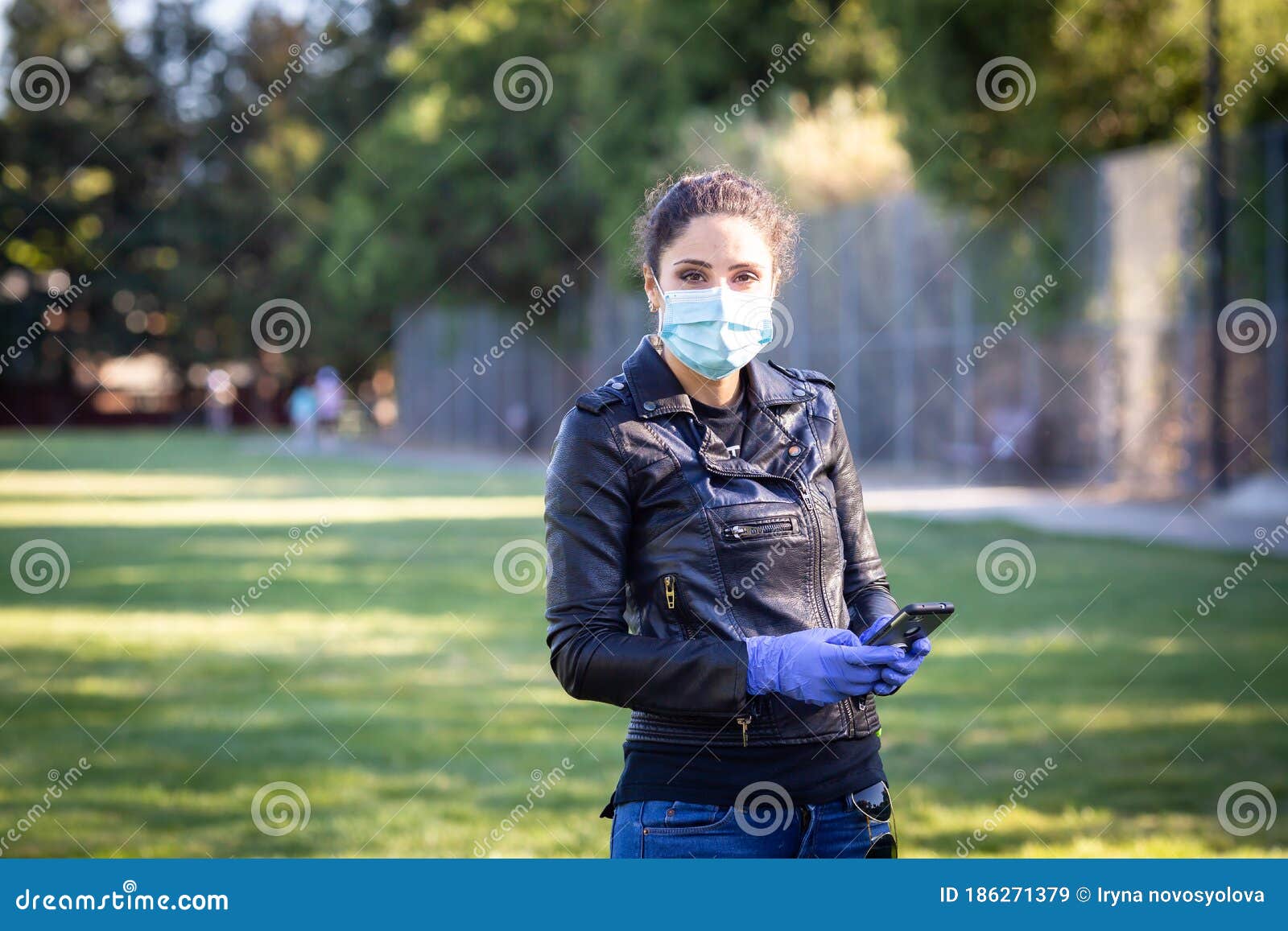 A Woman in a Black Leather Jacket and Purple Latex Protective Gloves ...